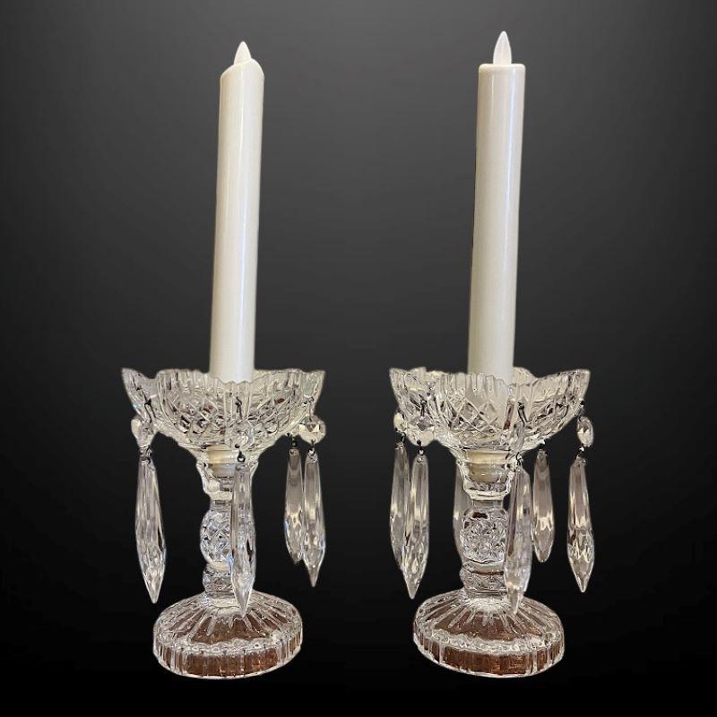 This lovely pair of crystal cut candlestick holders are diamond cut with a gradooned circular base.

The shaped drip dish holds delicate hanging crystal prisms, they are both in excellent condition.