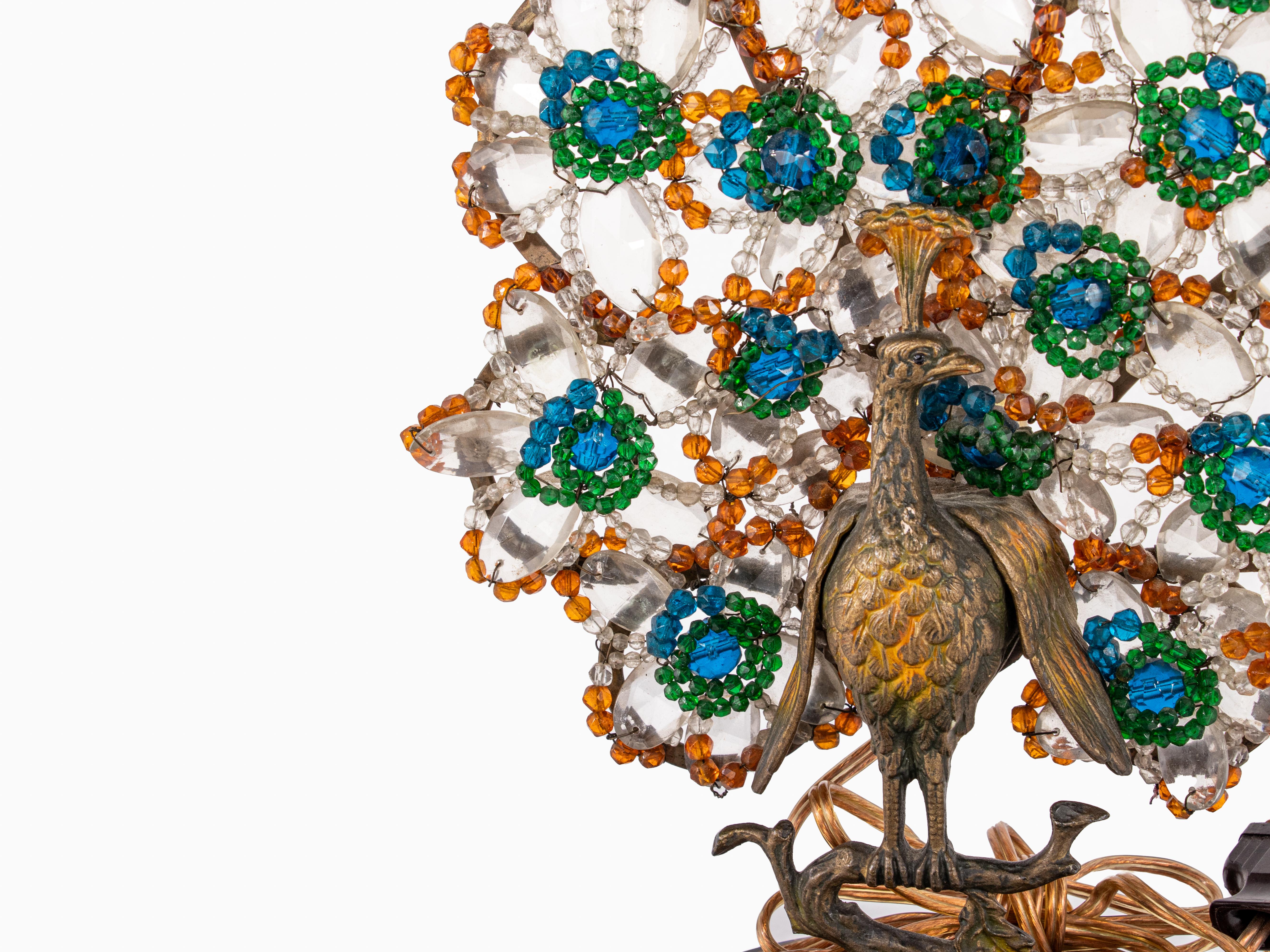 Pareja de lámparas de sobremesa de cristal checo en forma de pavos reales. Los pájaros de bronce dorado se posan con elegancia en sinuosas ramas sobre bases de mármol ébano, pareciendo casi congelados en el tiempo, su presencia a la vez majestuosa y