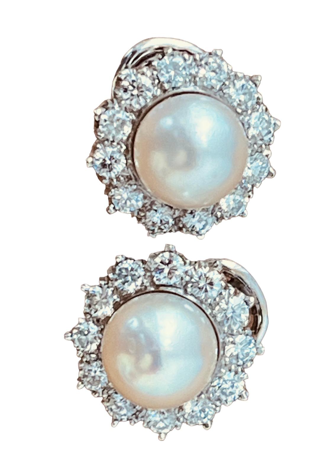 A pair of cultured pearl and diamond earclips mounted in platinum, 10.1 grams gross weight. Total diameter: 1.2cm (12mm). The 9mm cultured pearls surrounded by round brilliant cut diamonds weighing a total 2.40ct. G/H colour, VS quality. Circa