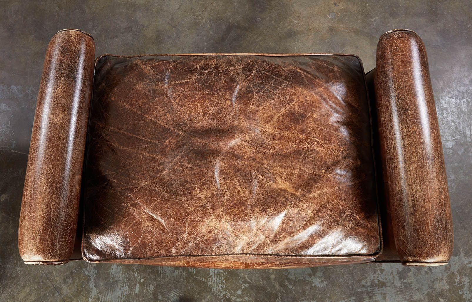 Un par de asientos de forma curvilínea, tapizados posteriormente en cuero, con decoración de tachuelas en los bordes perimetrales y cojines en los asientos. Atractiva y cómoda.
