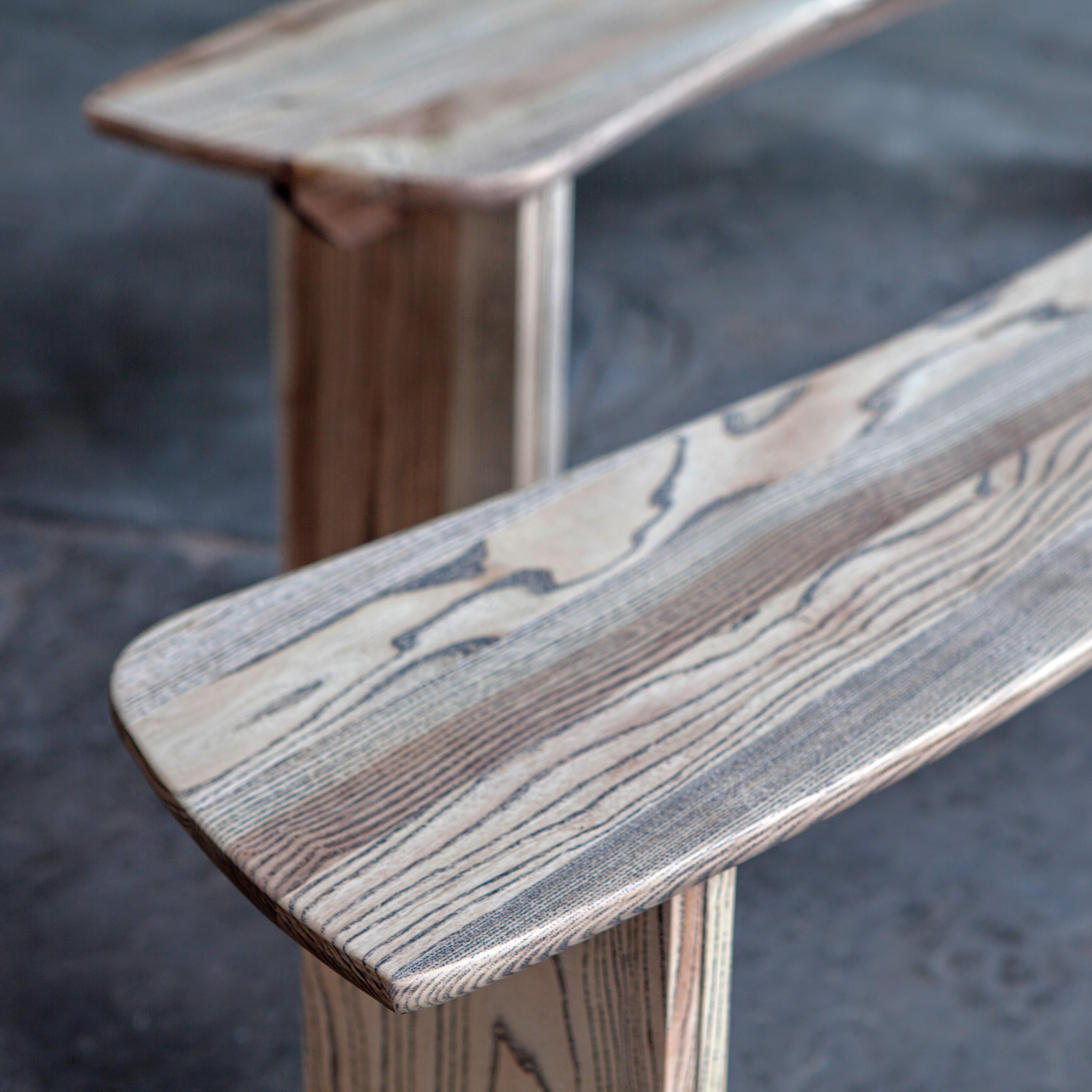 Deux bancs incurvés en frêne, grain ébène et finition huile blanche. 
Ils peuvent être fabriqués en différentes dimensions et en différents bois.
 