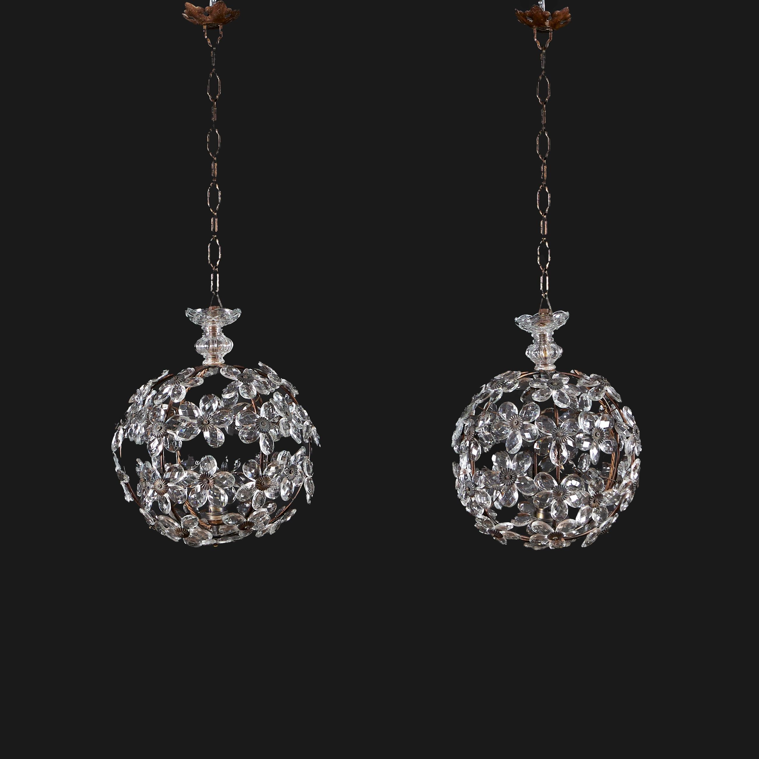 France, circa 1940

A pair of unusual cut glass and bronze lanterns, of spherical form, decorated with daisy flowers throughout, the petals in cut glass with bronze paterae to the centres. After Maison Bagues.

Height with chain           