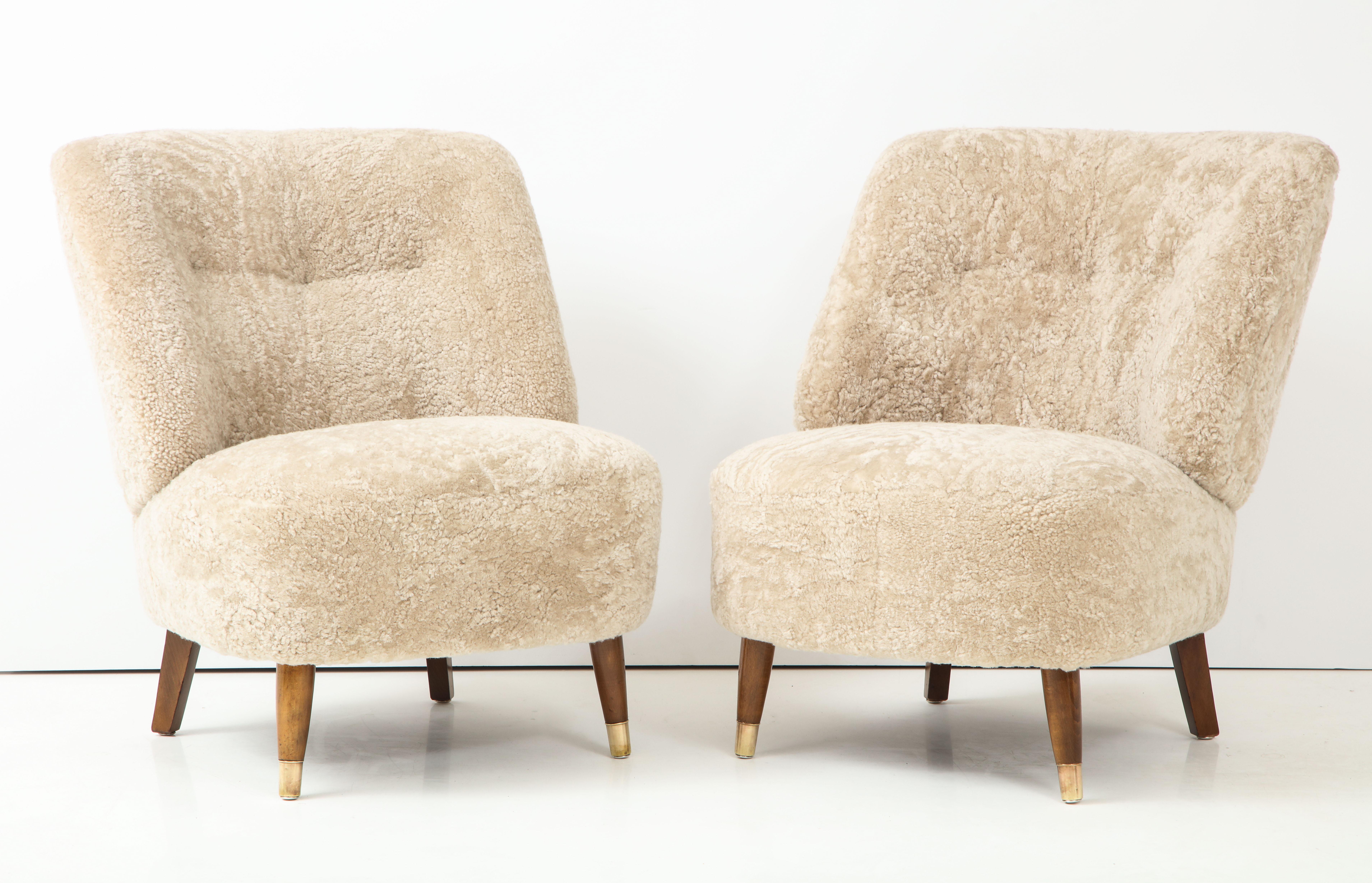 A pair of Danish sheepskin upholstered chairs, circa 1930s, each with a generous slightly curved backrest, full seat raised on turned beechwood legs ending with brass sabots. New Swedish Gottland sheepskin. Great scale and comfort.