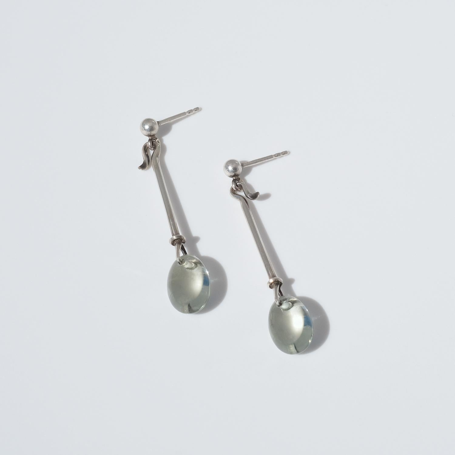 These sterling silver earrings are adorned with polished prasiolite gemstones, a gemstone with a divine greenish color. The earrings are part of Vivianna Torun Bülow Hübe's world known serie Dew Drop, which she designed in the mid 1950s, a