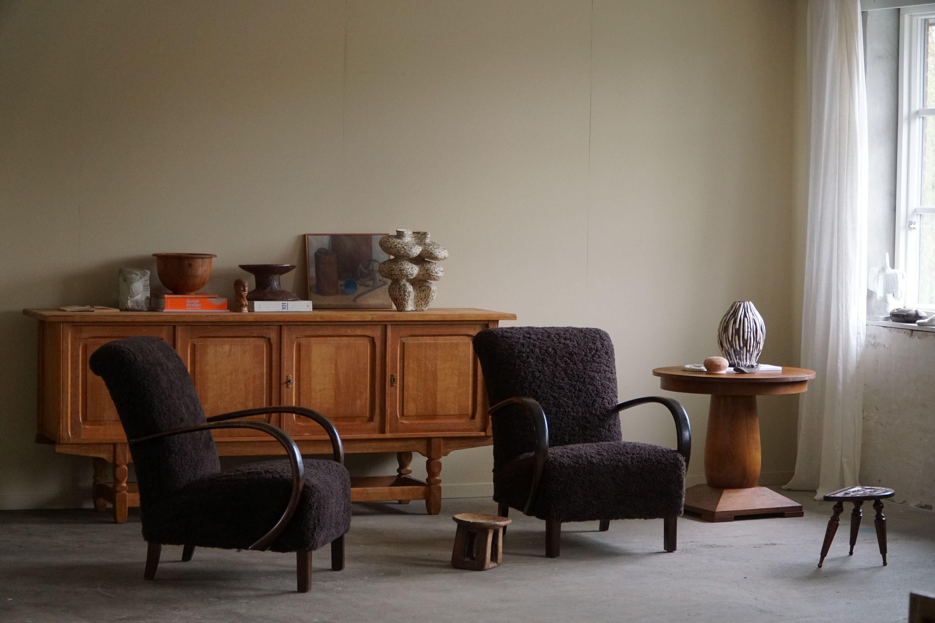 A beautiful pair of curved lounge chairs, reupholstered in shearling lambswool, designed by a Danish cabinetmaker in the 1940s. Made of sturdy beech wood and adorned with cozy lambswool upholstery, these chairs exude timeless elegance and comfort.