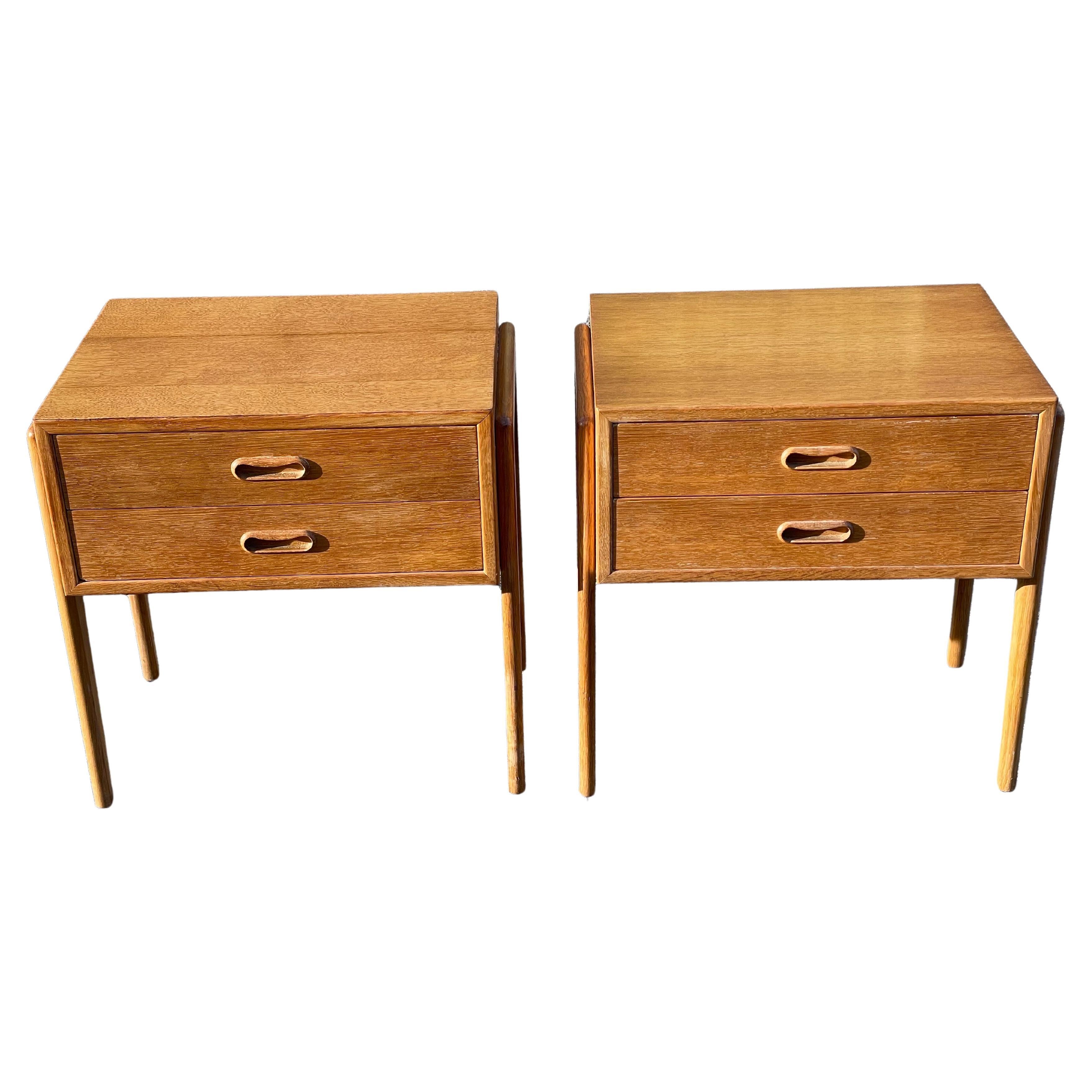 A timeless duo of Danish Mid-Century Modern nightstands in exquisite oak, boasting the signature craftsmanship of Ølholm Møbelfabrik from the iconic 1960s era. These nightstands seamlessly blend form and function with their two spacious drawers and