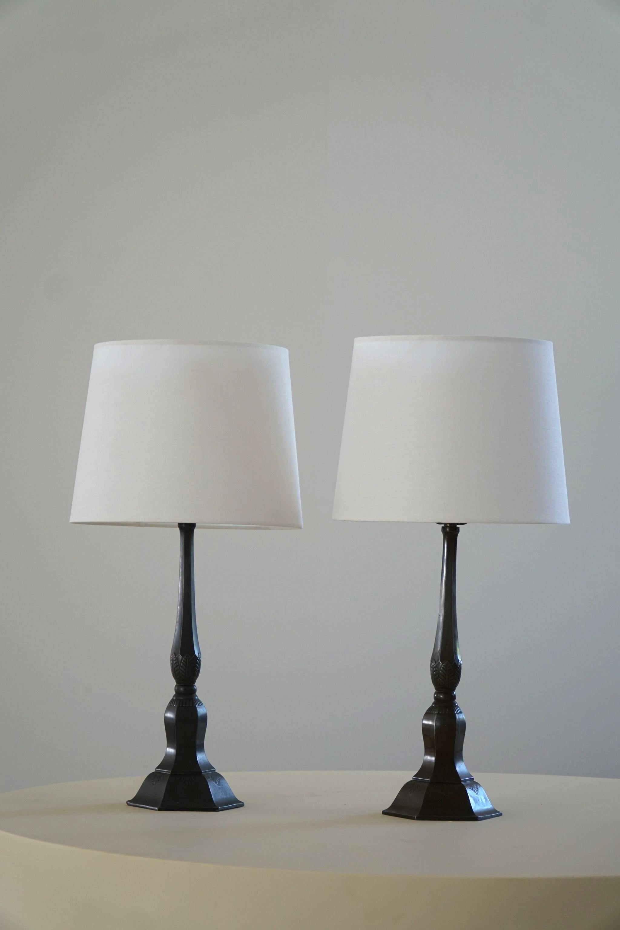 Ein Paar Tischlampen aus patiniertem Diskometall. Hergestellt vom dänischen Designer Just Andersen in den 1920er Jahren. Darunter unterschrieben. 

Just Andersen (1884-1943) ist ein bedeutender Vertreter des modernen dänischen Neoklassizismus.