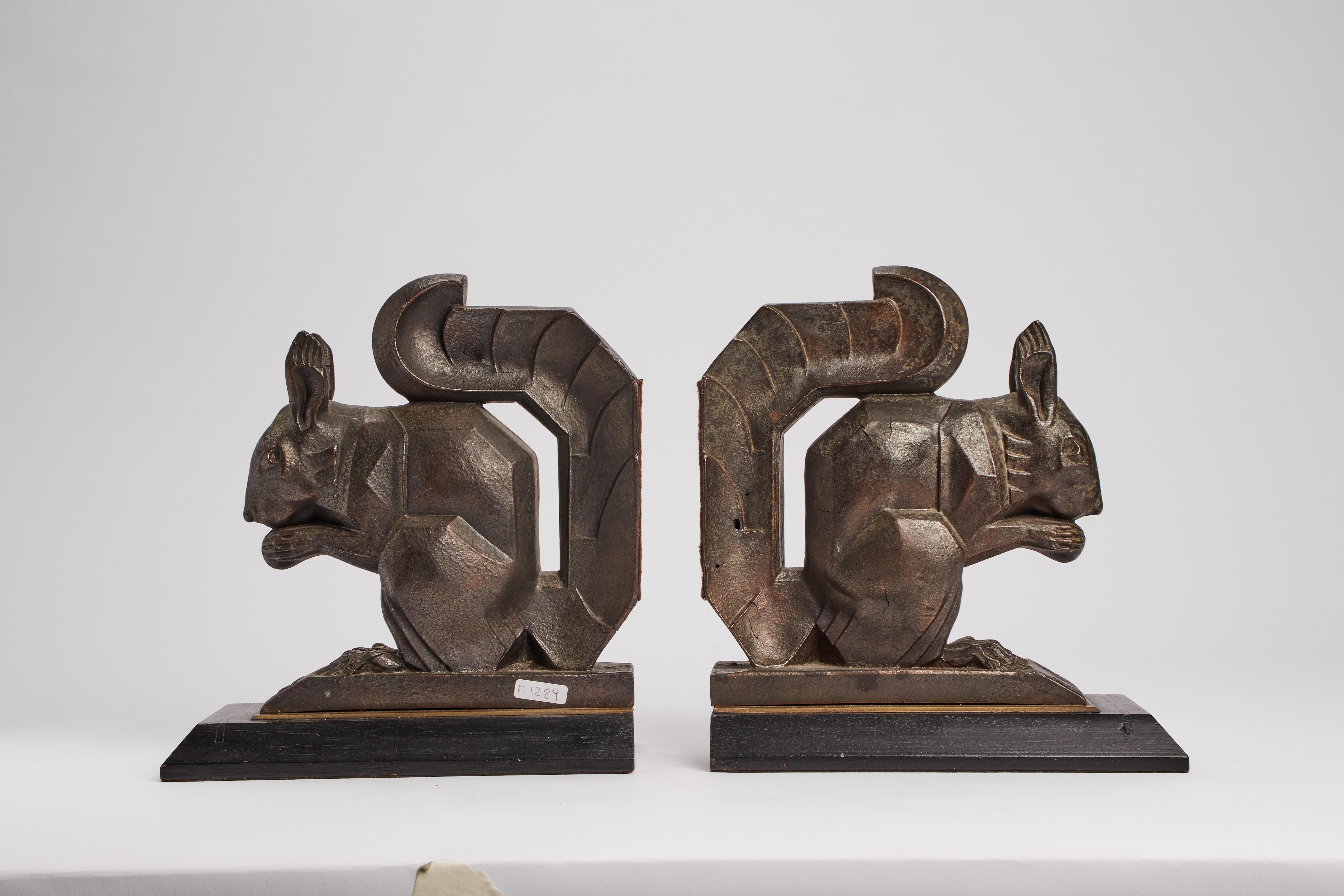 Pair of Art Deco bookend made out of copper alloy with withe metal patina and a wooden base, representing squirrels. France, circa 1930.