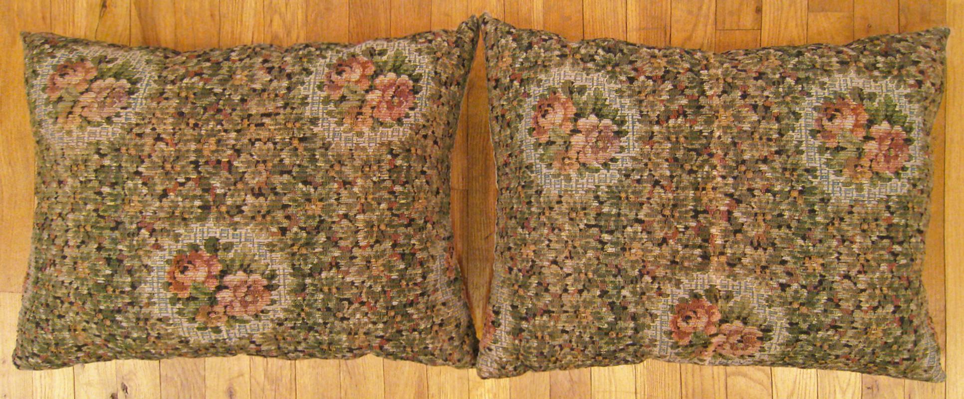 A pair of antique jacquard tapestry pillows ; size 2'0” x 1'8” each.

An antique decorative pillows with floral elments allover a green central field, size 2'0