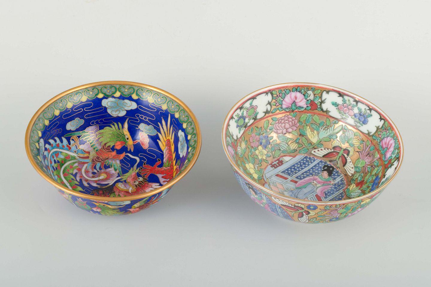 Paire de bols décoratifs chinois du 20e siècle. 
Un bol en porcelaine, décoré en couleurs polychromes d'une scène figurative, de fleurs et de papillons sur un fond doré. La base porte une marque Qianlong rouge. 
L'autre bol est en cloisonné, décoré