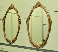 A Pair of Decorative Oval Gilt Wall Mirrors