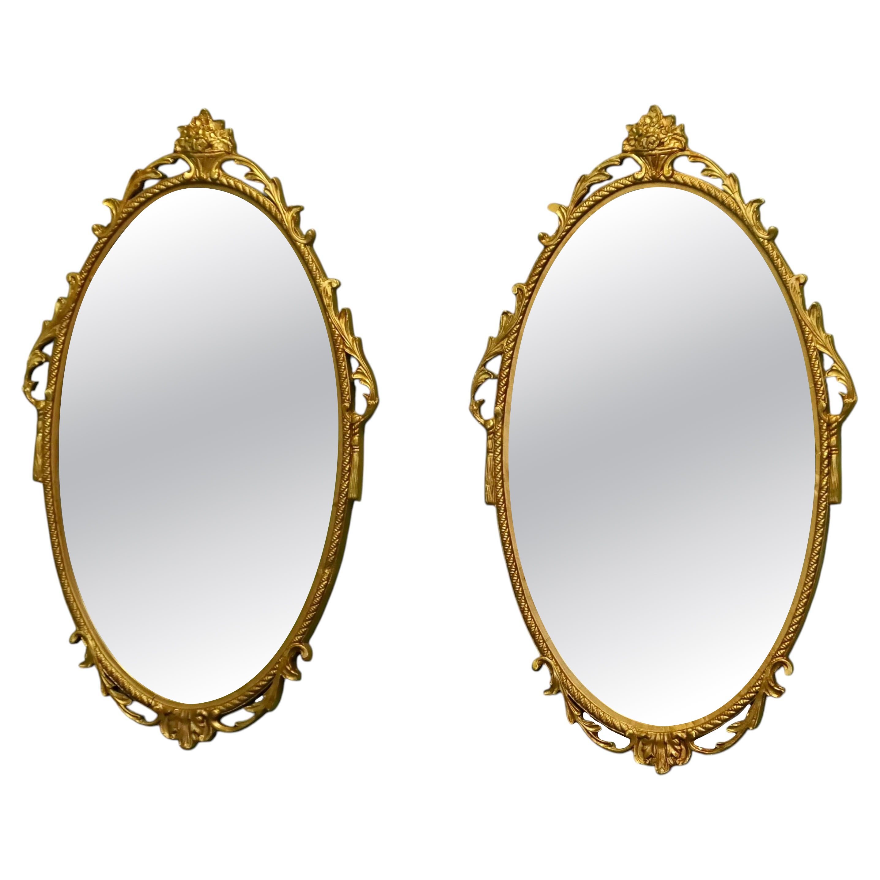 A Pair of Decorative Oval Gilt Wall Mirrors For Sale