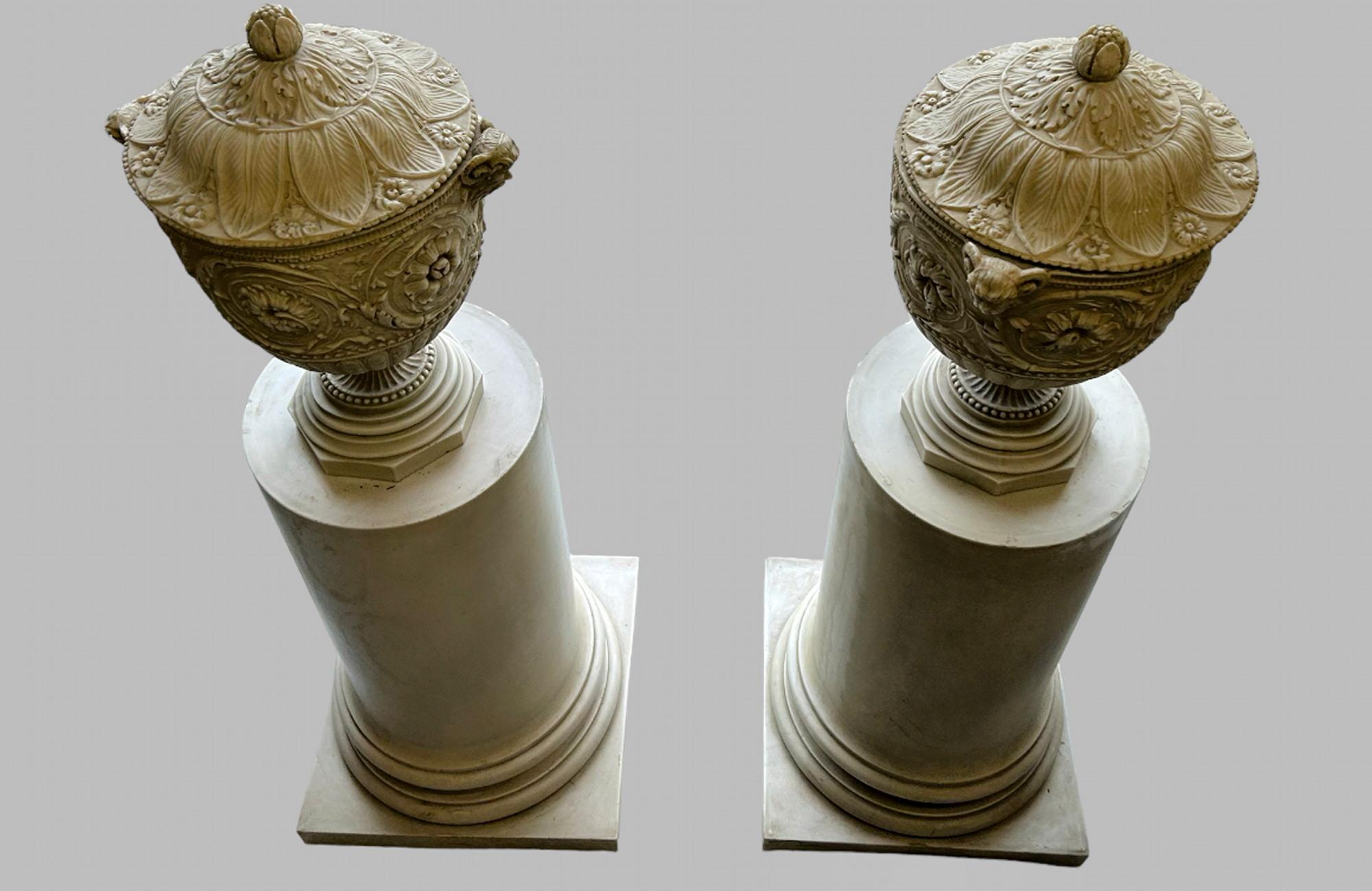Pair of Highly Decorative Decorative Pedestals, surmounted with lidded urns with satyr masks on composite half column plinths / stands . Urns 46 cm H, total height including stands 118 cm H. Extremely heavy but look fantastic in right setting.