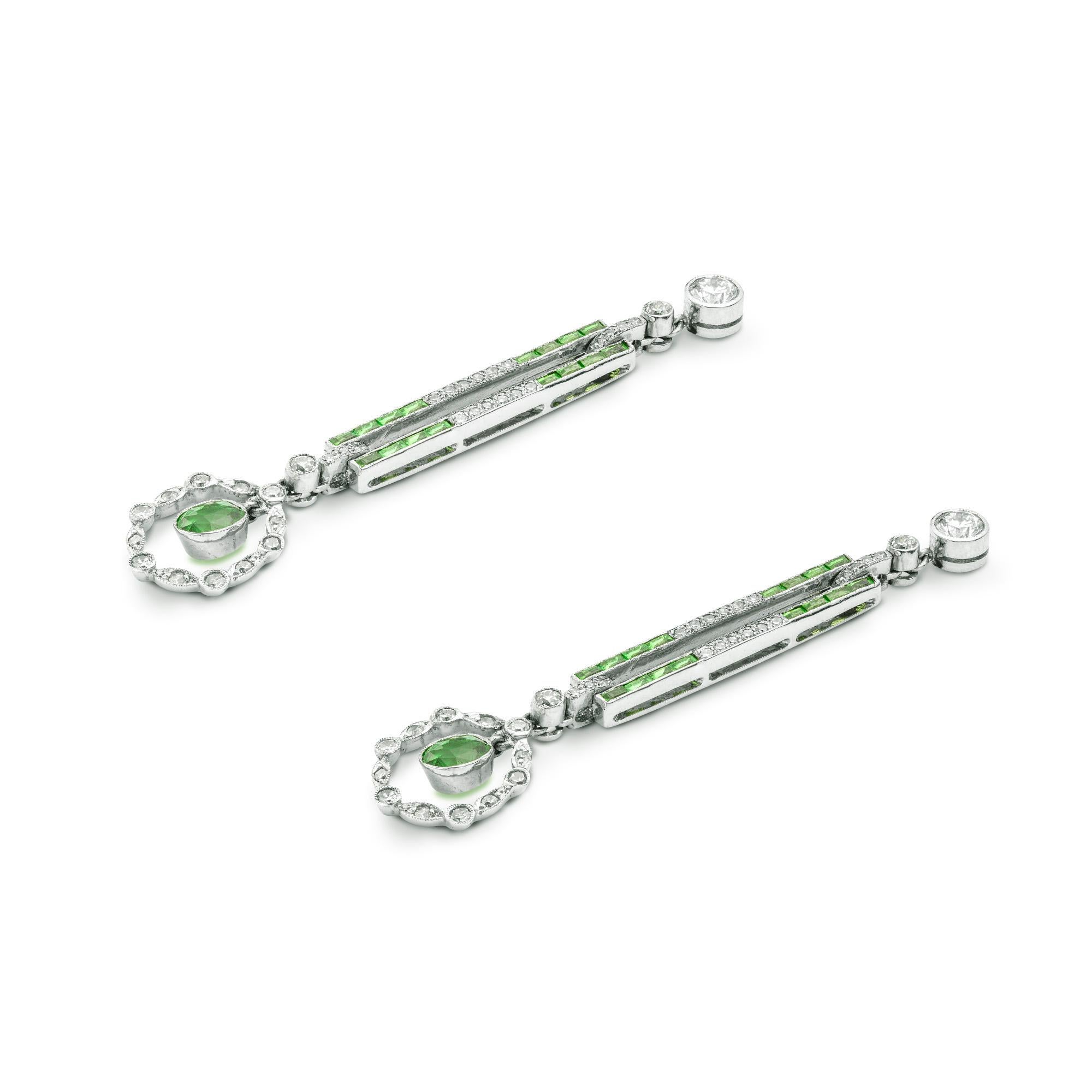 A pair of demantoid garnet and diamond drop earrings, each earring with an oval-cut demantoid-garnet surrounded by a flexible diamond-set cluster, suspended by rectangular centrally-open link, set with calibre-cut demantoid garnets and diamonds, the