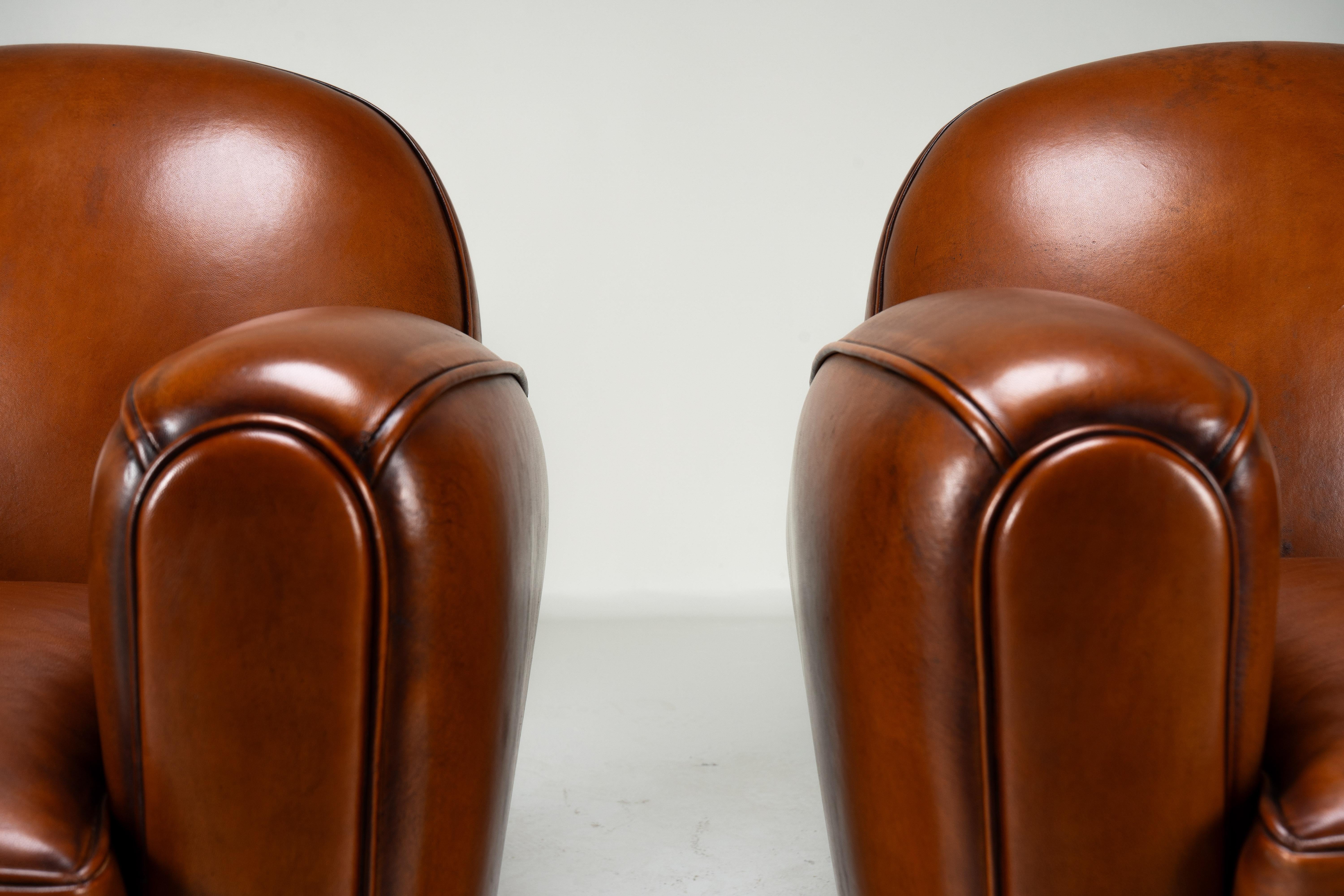 Cette paire de fauteuils club contemporains de style Art déco français est une pièce rare. Avec un design datant du mouvement Art Moderne des années 1920-1940, ces chaises illustrent une époque de style parisien. La couleur brun-noisette frappante a