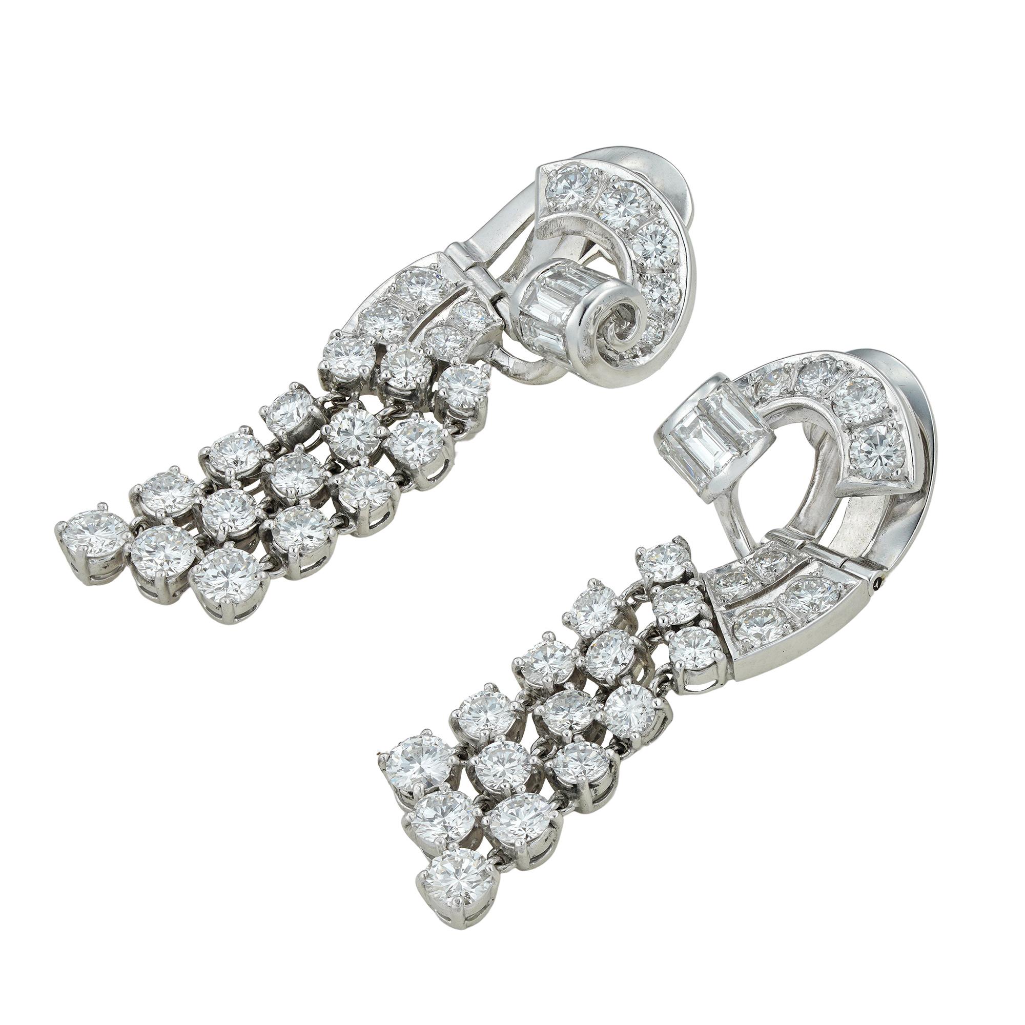A pair of vintage diamond drop earring, each earring consisting of three graduated articulated tassel drops, claw-set with fifteen round brilliant-cut diamonds, suspended from a scrolled style top, grain-set with ten graduated round brilliant- and