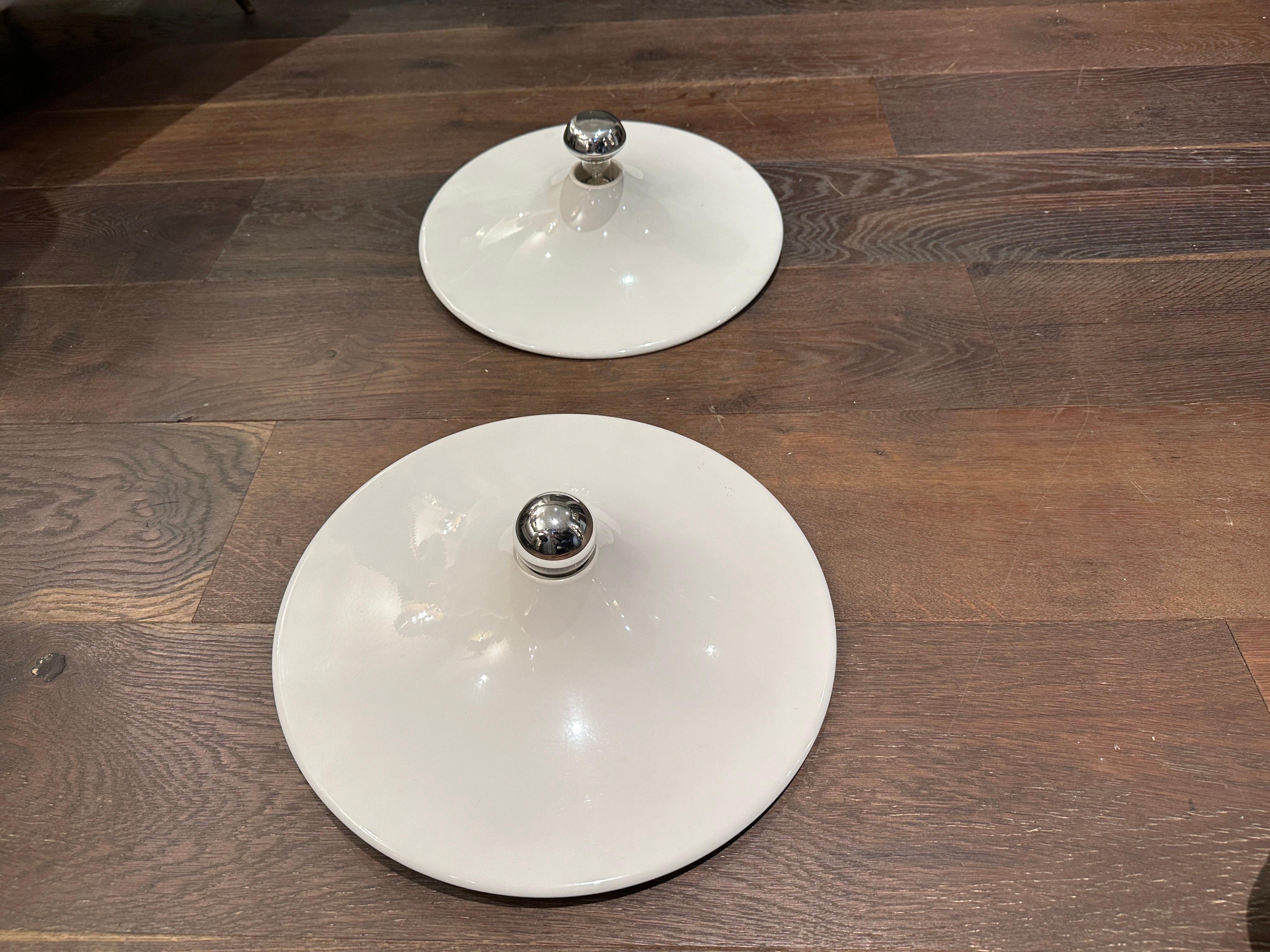 A  set of two disc wall lights, designed by Gianluigi Gorgoni. Manufactured by the Italian lighting company, Stilnovo in 1970's. The lights are made of an off white coated metal. They can be used for both flush mount ceiling lights or wall