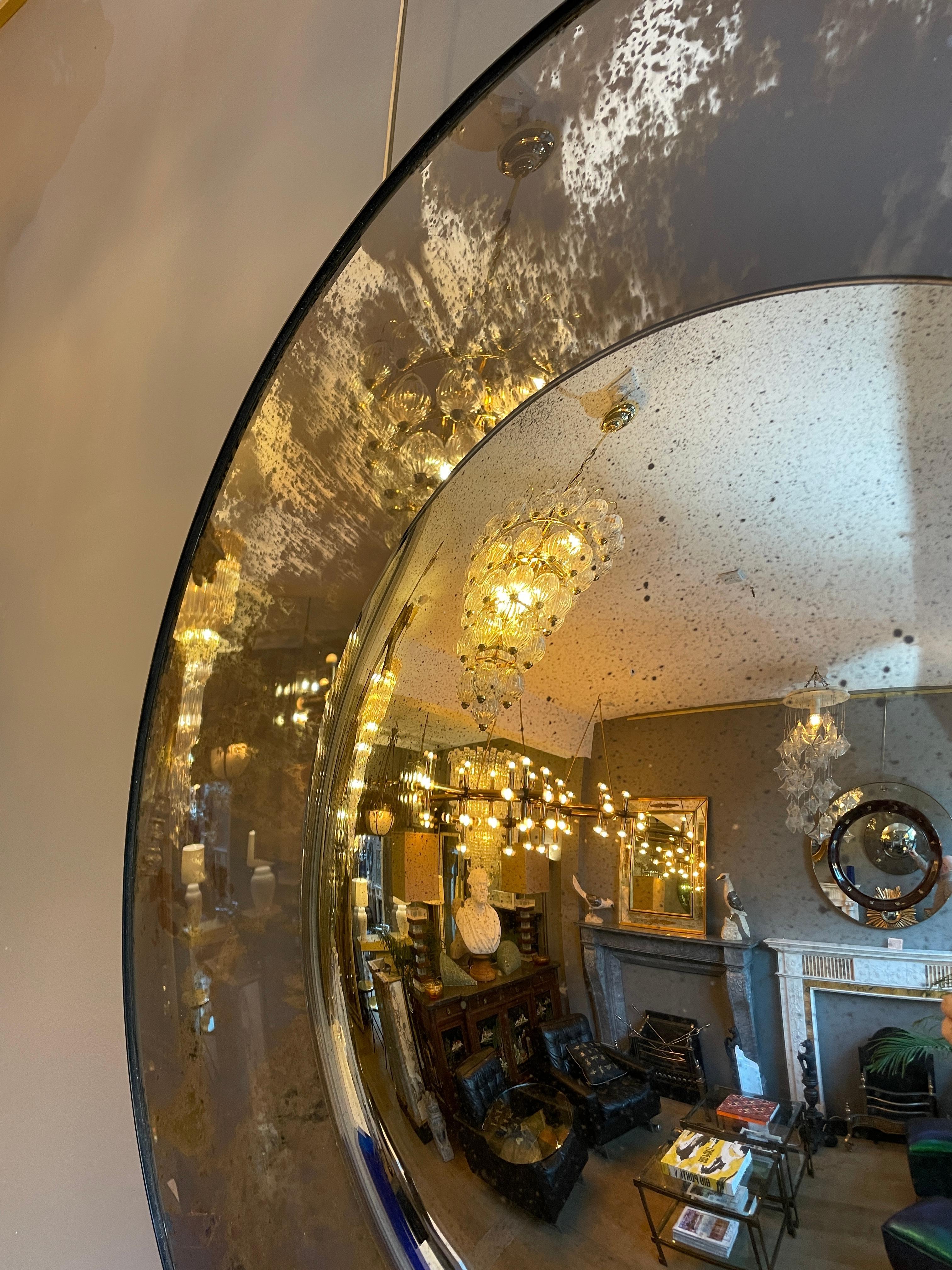 A pair of large circular convex mirror, with outer convex in very distressed silver mirror, with inner convex less distressed, with a bronze banded frame finish.