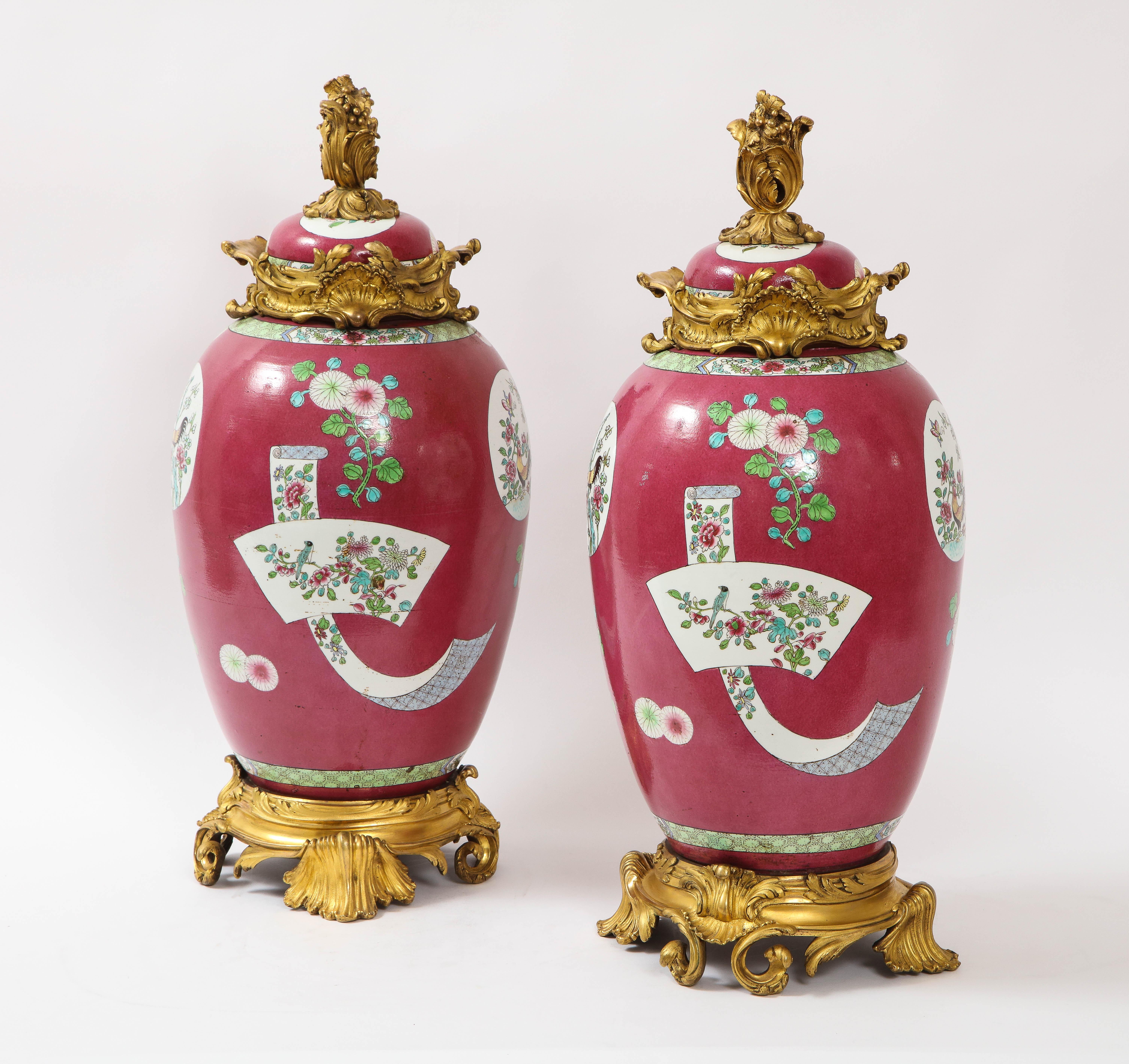 A fabulous and large pair of 19th century Louis XVI style doré bronze mounted Chinese porcelain rooster red ground covered jars/covered vases. The porcelain is of a red ground with hand painted enamel decorations of Chinese roosters, parrots,