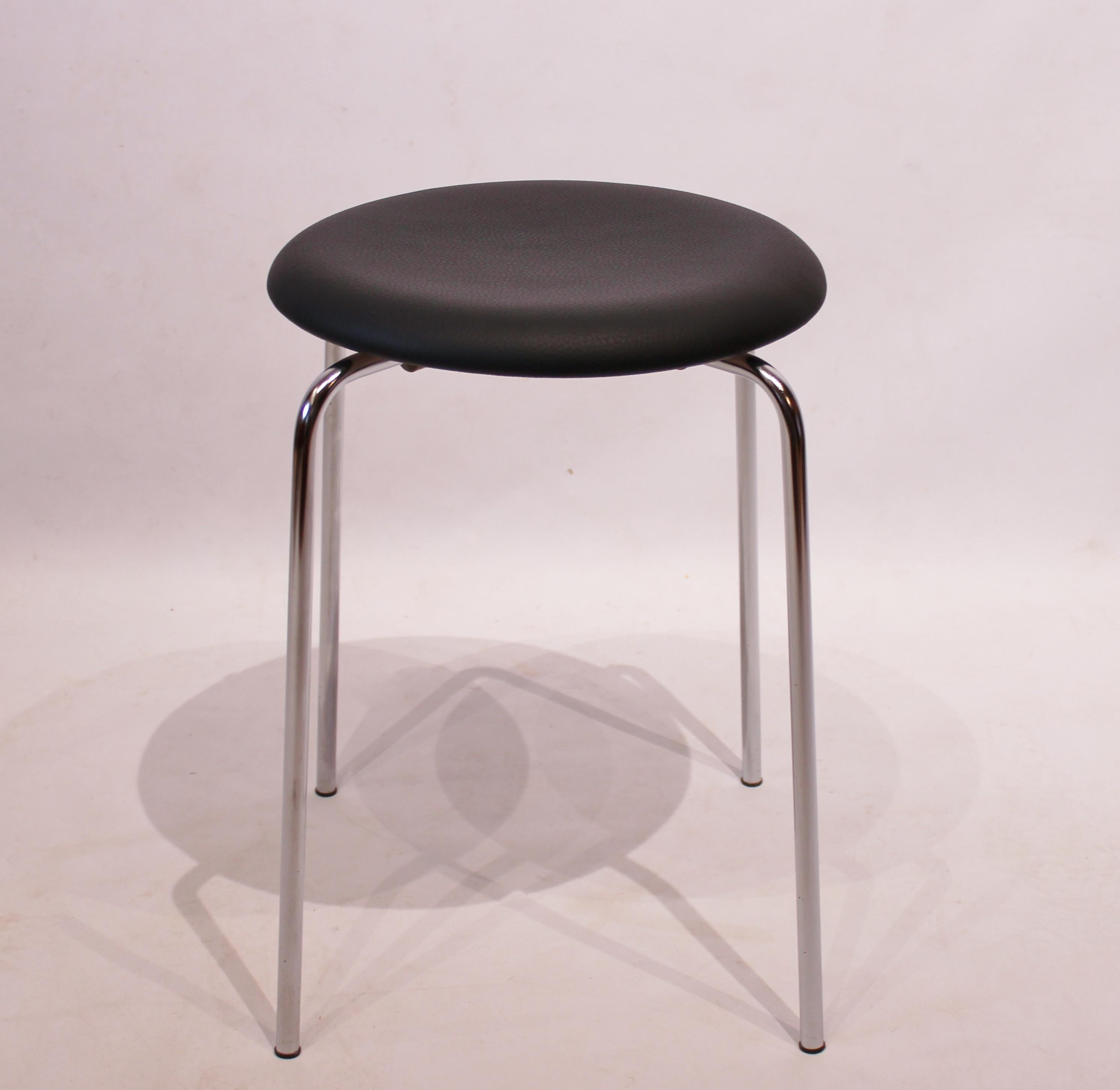 The pair of dot stools upholstered with black leather, designed by Arne Jacobsen and manufactured by Fritz Hansen in 1971, is a stylish and functional addition to any interior space.

Arne Jacobsen was a Danish architect and designer known for his