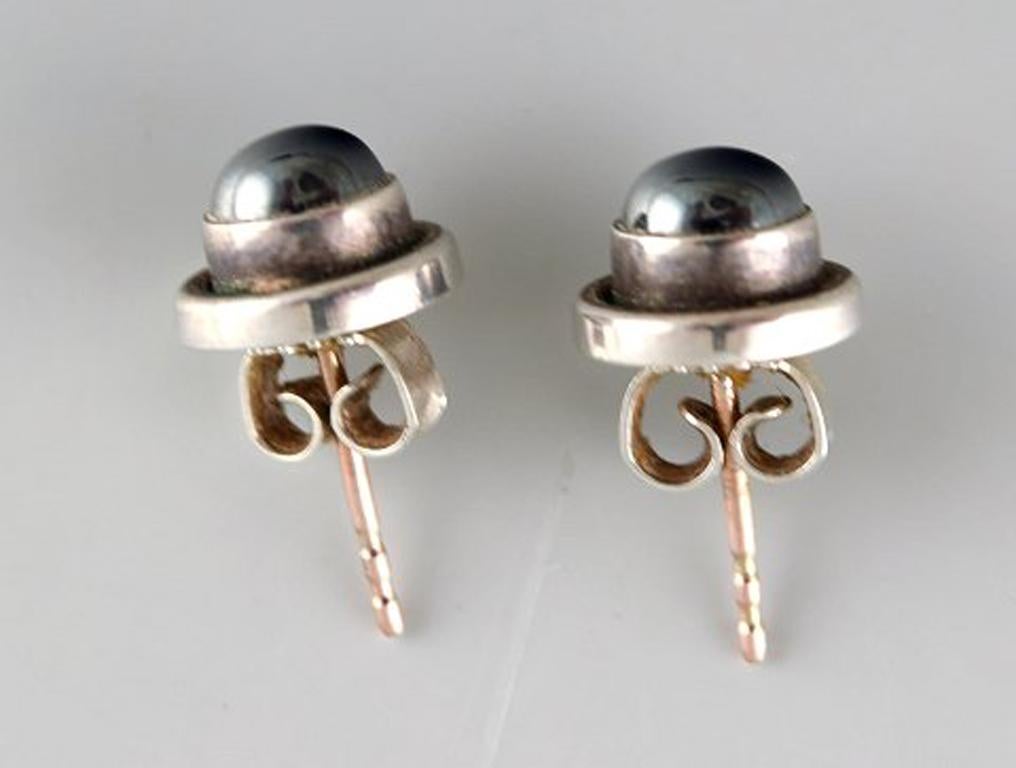 A pair of ear studs in sterling silver by Georg Jensen with cabochon cut hematite.
Stamped.
In very good condition.
Diameter: 9 mm.