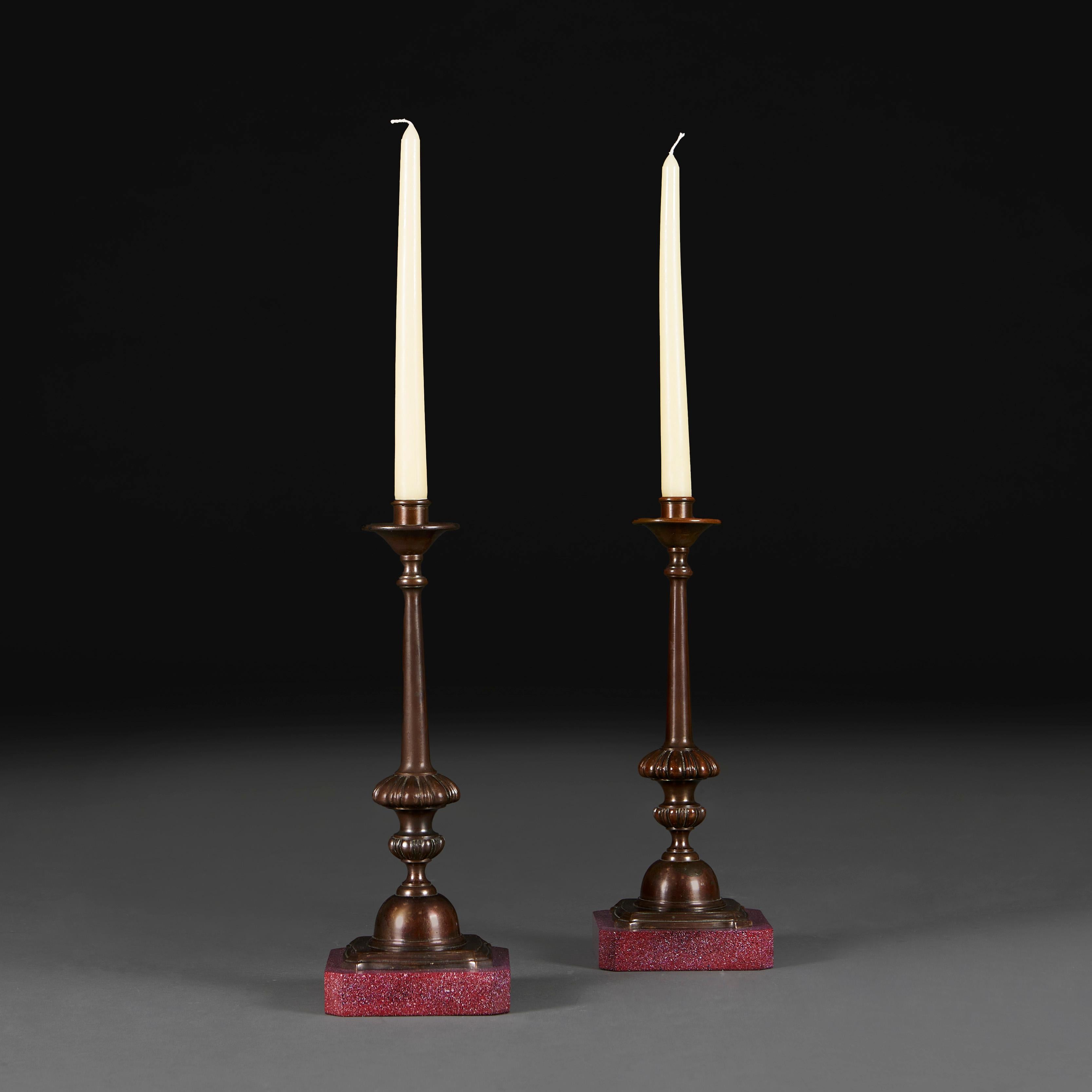 England, circa 1820

A pair of early nineteenth century bronze candlesticks, with tapering stems and urn shaped bases, supported on faux porphyry plinths.

Height 33.00cm

Width 12.00cm