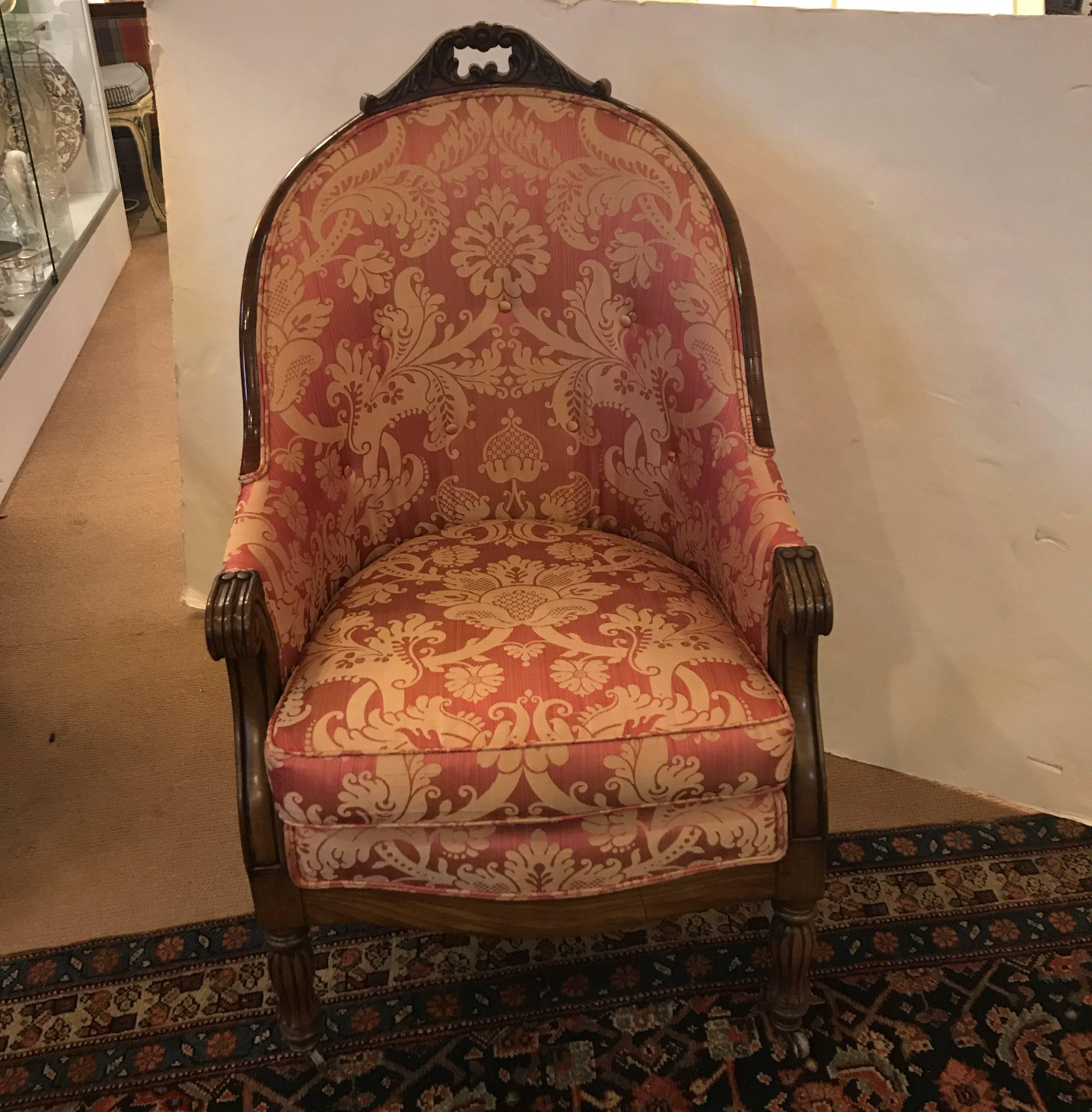 A fine pair of Louis XVI style hand-carved mahogany upholstered Berger chairs with new damask fabric. The arched crest surmounted by pierced leaf and scroll carving with down-swept sides ending with scrolled hand holds. The upholstered seats raised