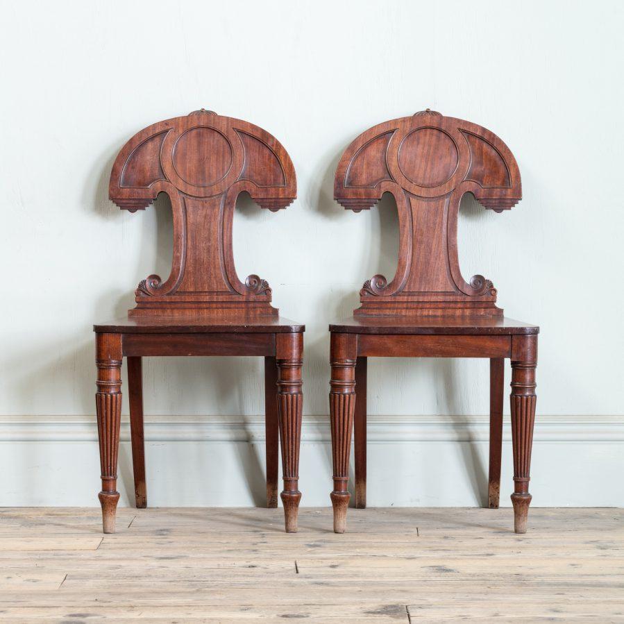 Attributed to Gillows, each with a shaped and scroll carved back, on solid seat with tapering, turned, and reeded legs.