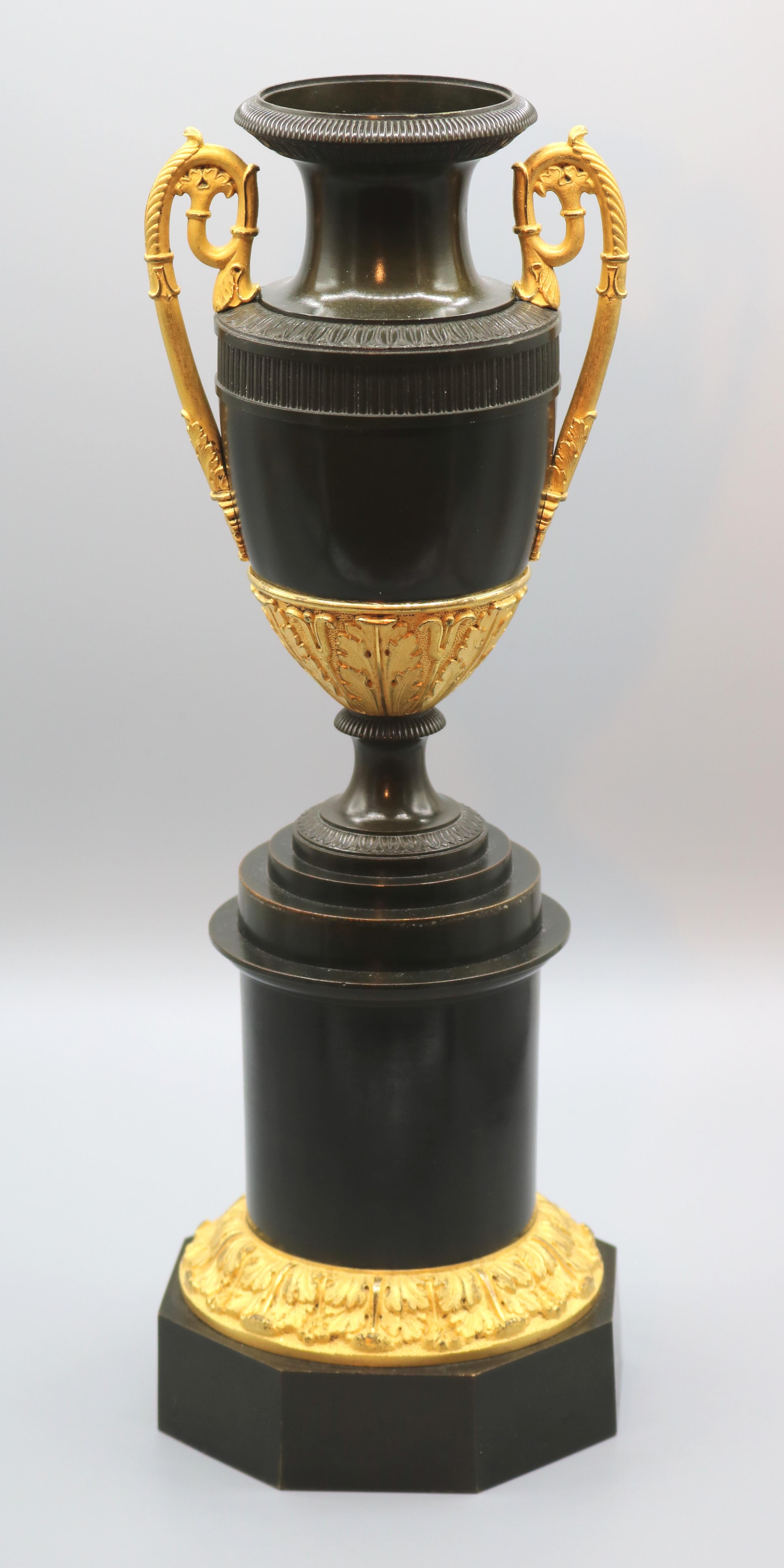 Ein Paar klassischer Vasen aus Bronze und Ormolu aus dem frühen 19. Jahrhundert mit detaillierten Blatt- und Rillendetails, deren Griffe auf gestuften Sockeln stehen, die auf achteckigen Sockeln mit Akanthuskragen enden.