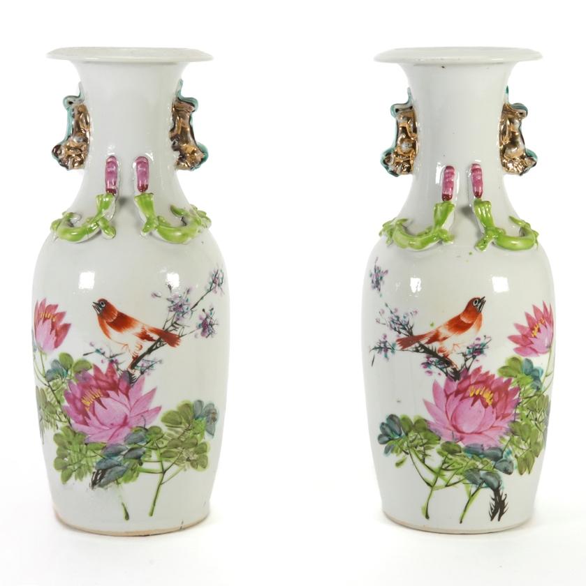 A pair of early 20th century Chinese famille rose porcelain vases, hand painted with peony and a bird on one side and Chinese calligraphy in verse to the opposing side, with applied salamander decoration, gilded temple dog handles.

Size: H 25
