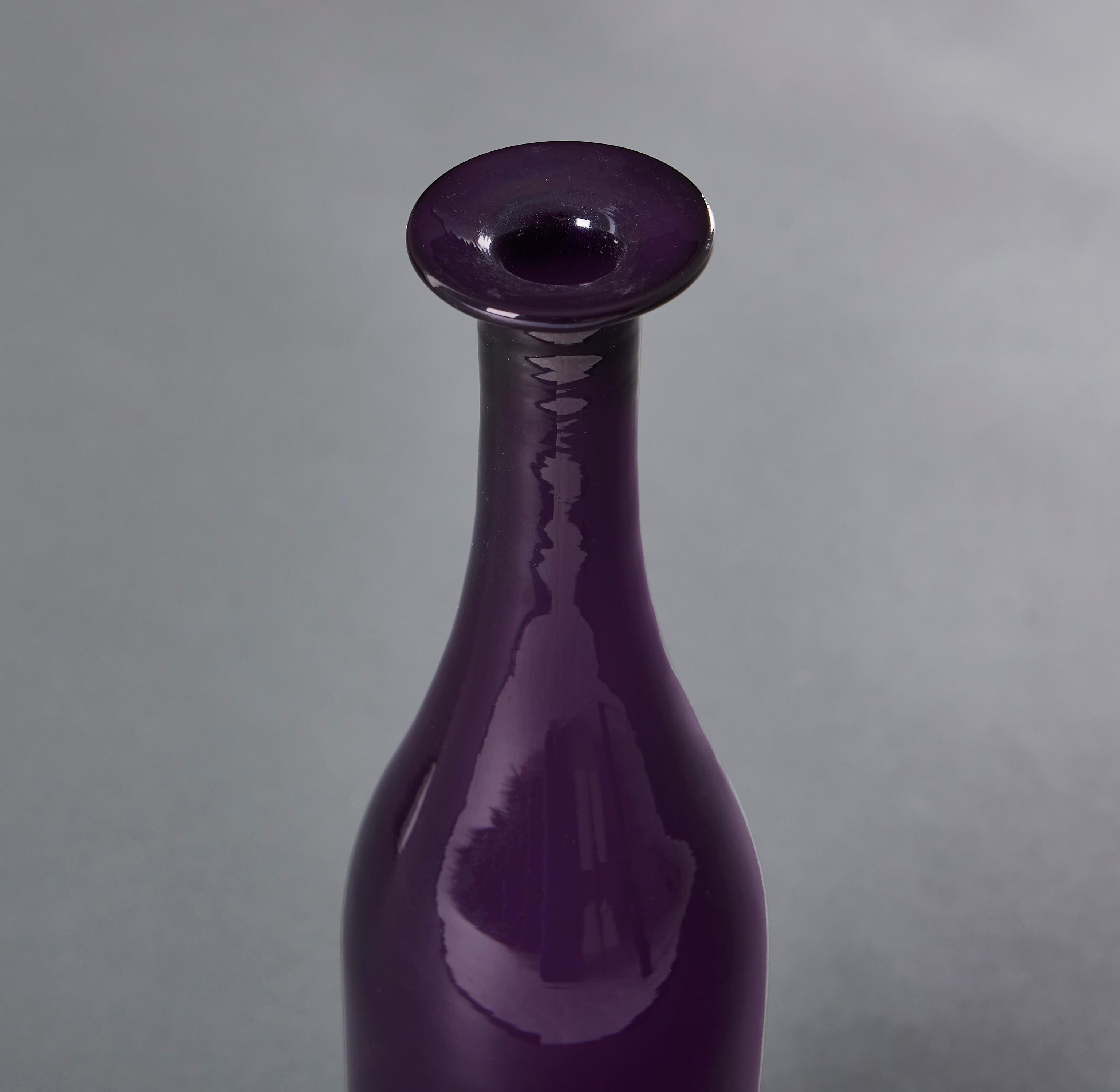 A pair of late nineteenth century - early twentieth century amethyst purple glass water carafes with slender necks. 