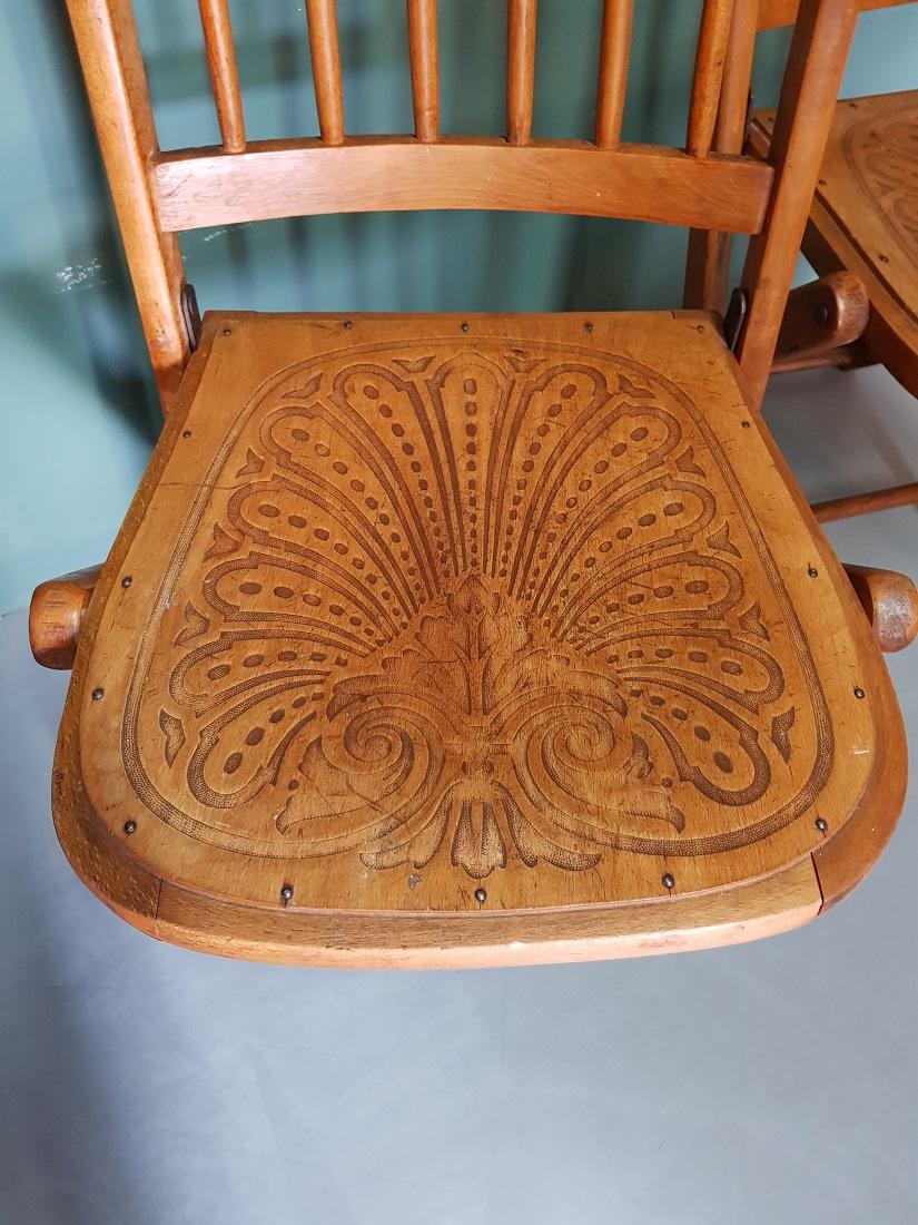 A fantastic pair of old Thonet style folding chairs, both with a relief-pressed seat and back bars, from the first half of the 20th century. 

The measurements are:
Depth 38 cm/ 14.9 inch.
Width 36 cm/ 14.1 inch.
Height 84 cm/ 33 inch.
Seat