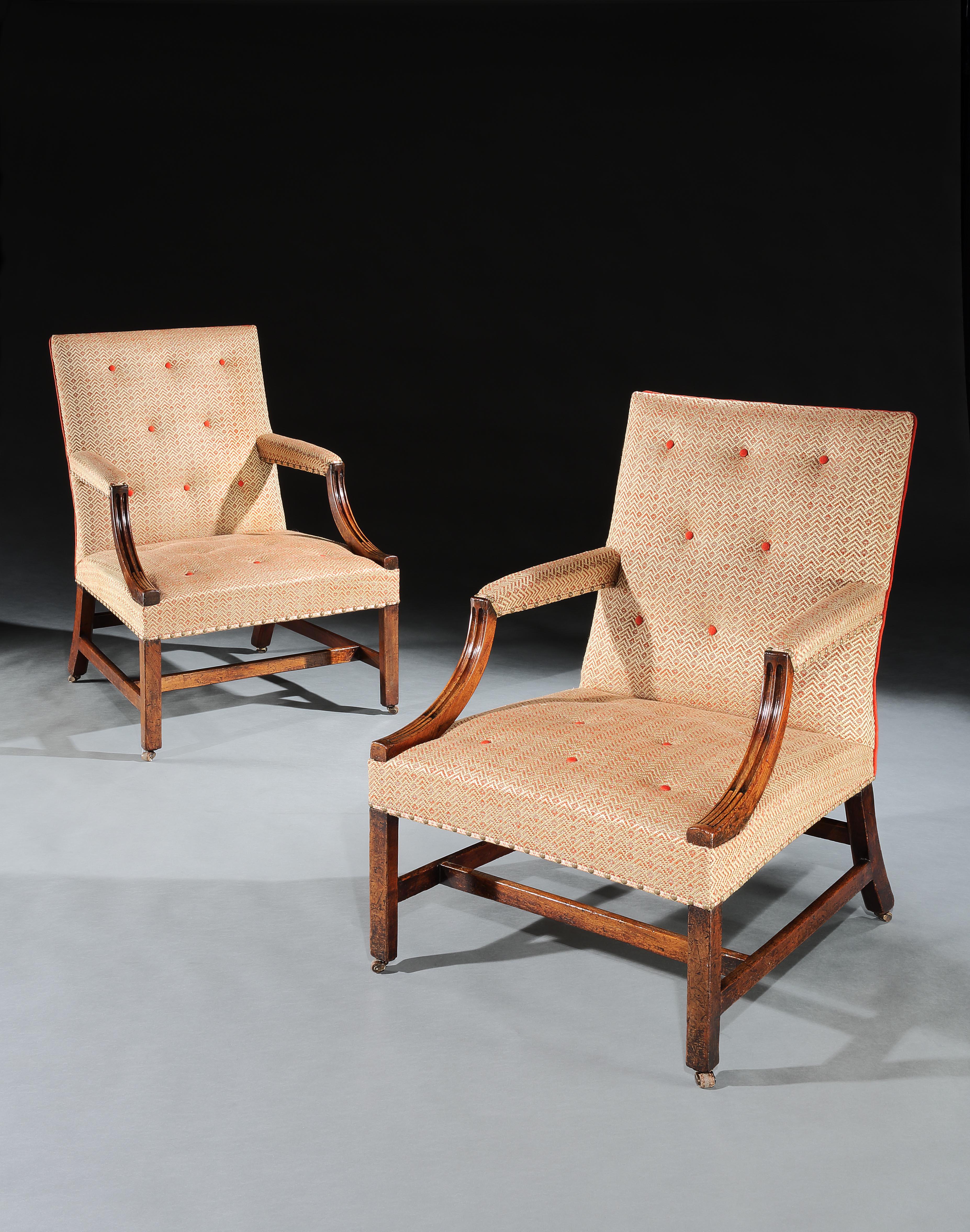 A pair of early George III Gainsborough open armchairs in light colored mahogany with reeded arms standing on square championed legs united by stretchers on leather castors.




 