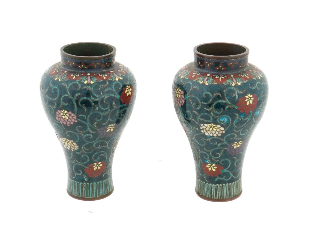 A pair of antique Japanese early Meiji period cloisonne vases, attributed to the master artisan Namikawa Yasuyuki, 1845 to 1927.. Each vase is adorned with intricate flower and foliate motifs made using the cloisonne enamel technique. The meticulous