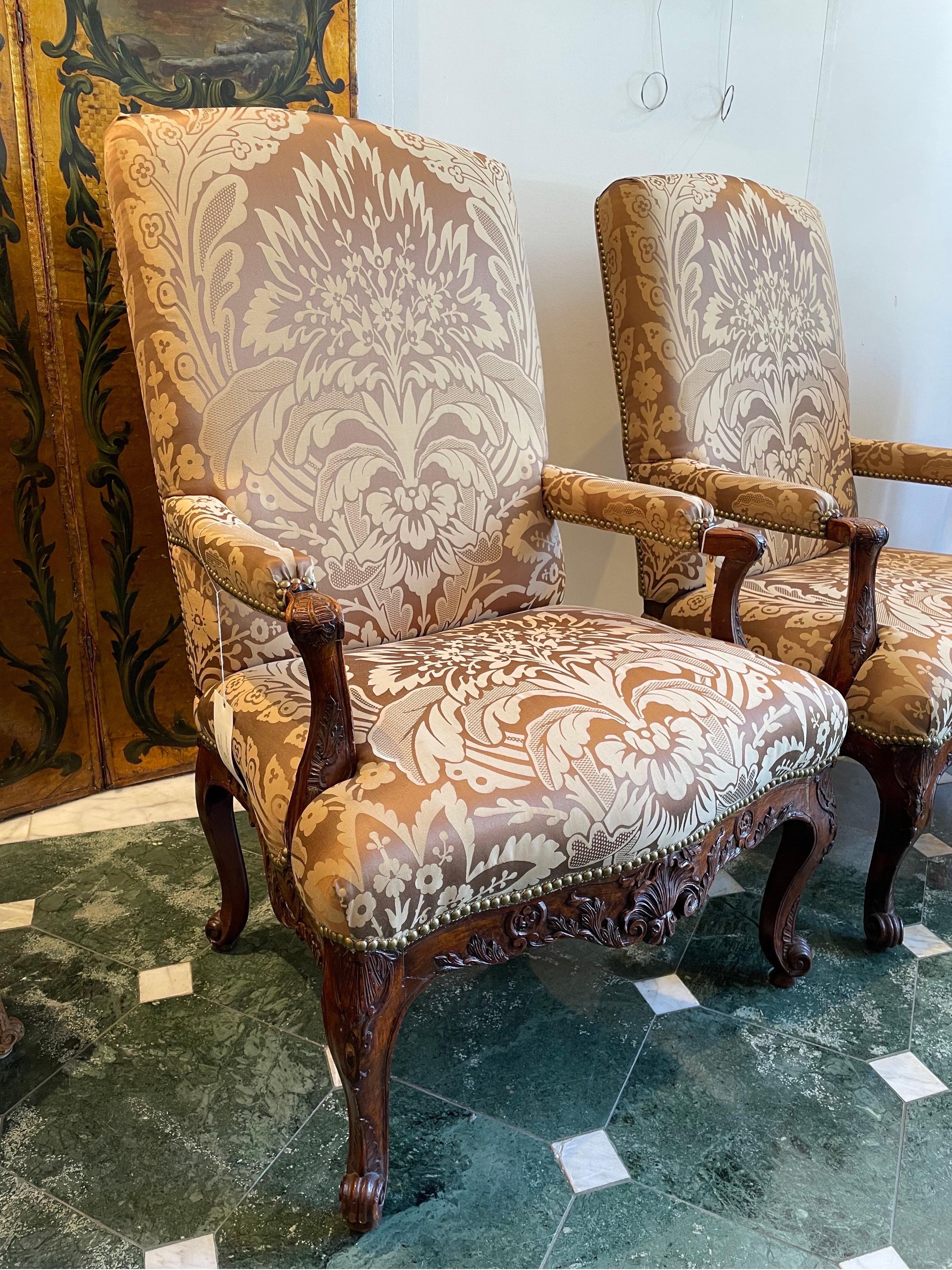 A Pair of Early Louis XV Walnut Fauteuils A La Reine, 18th Century

With square back and yoke arch top rail, the exposed hand rests carved with leaves, on scroll supports to serpentine seat rails carved with conforming foliated reliefwork, on
