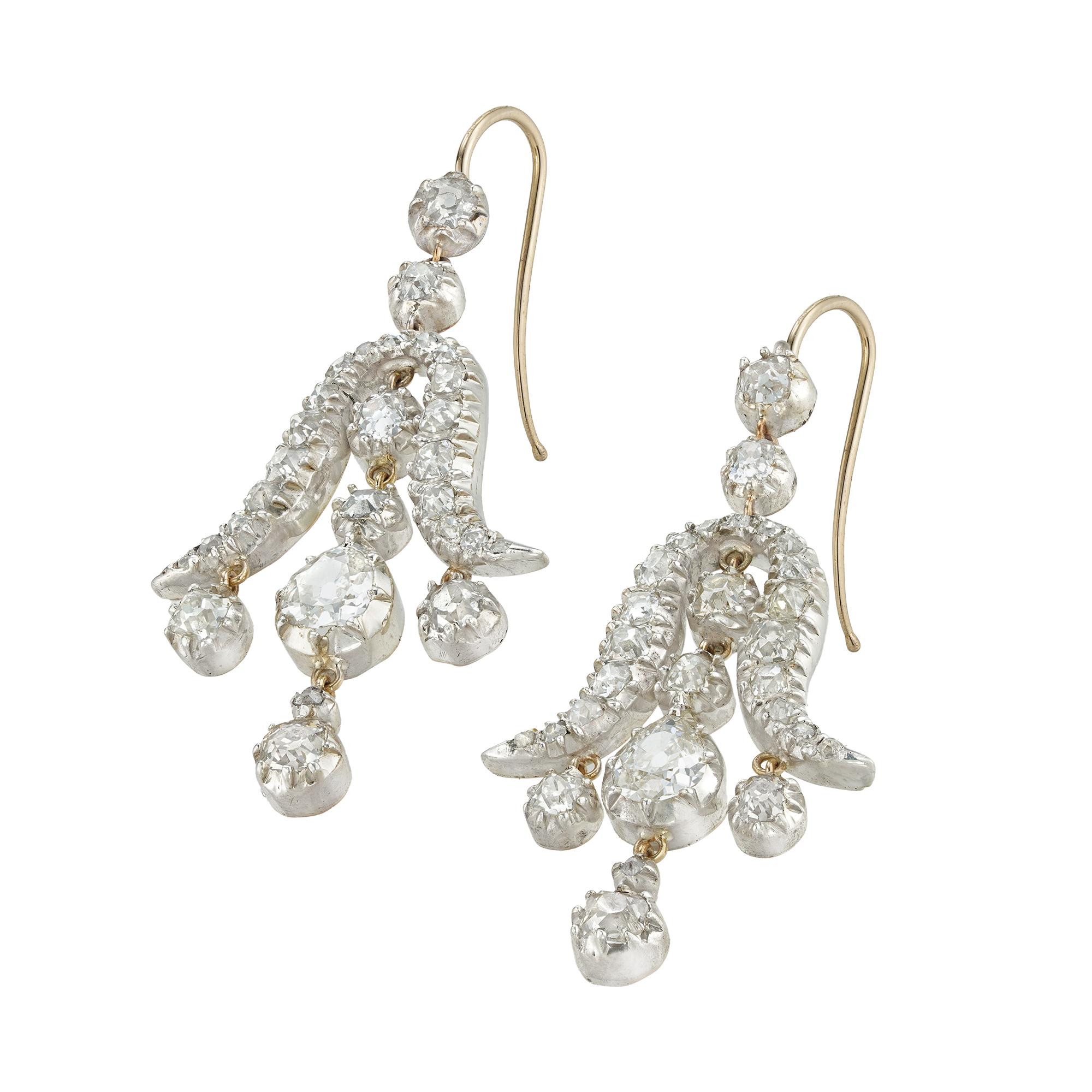 A pair of early Victorian diamond drop earrings, each earing with an inverted tulip-shape motif, encrusted with small old mine-cut diamonds, with a run of four diamonds to the centre, all surmounted by two old-cut diamonds, the diamonds estimated to