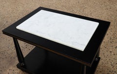 A pair of ebonized and gilt marble top end tables on ball feet circa 1950.