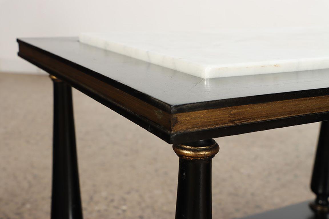 Marble A pair of ebonized and gilt marble top end tables on ball feet circa 1950. For Sale