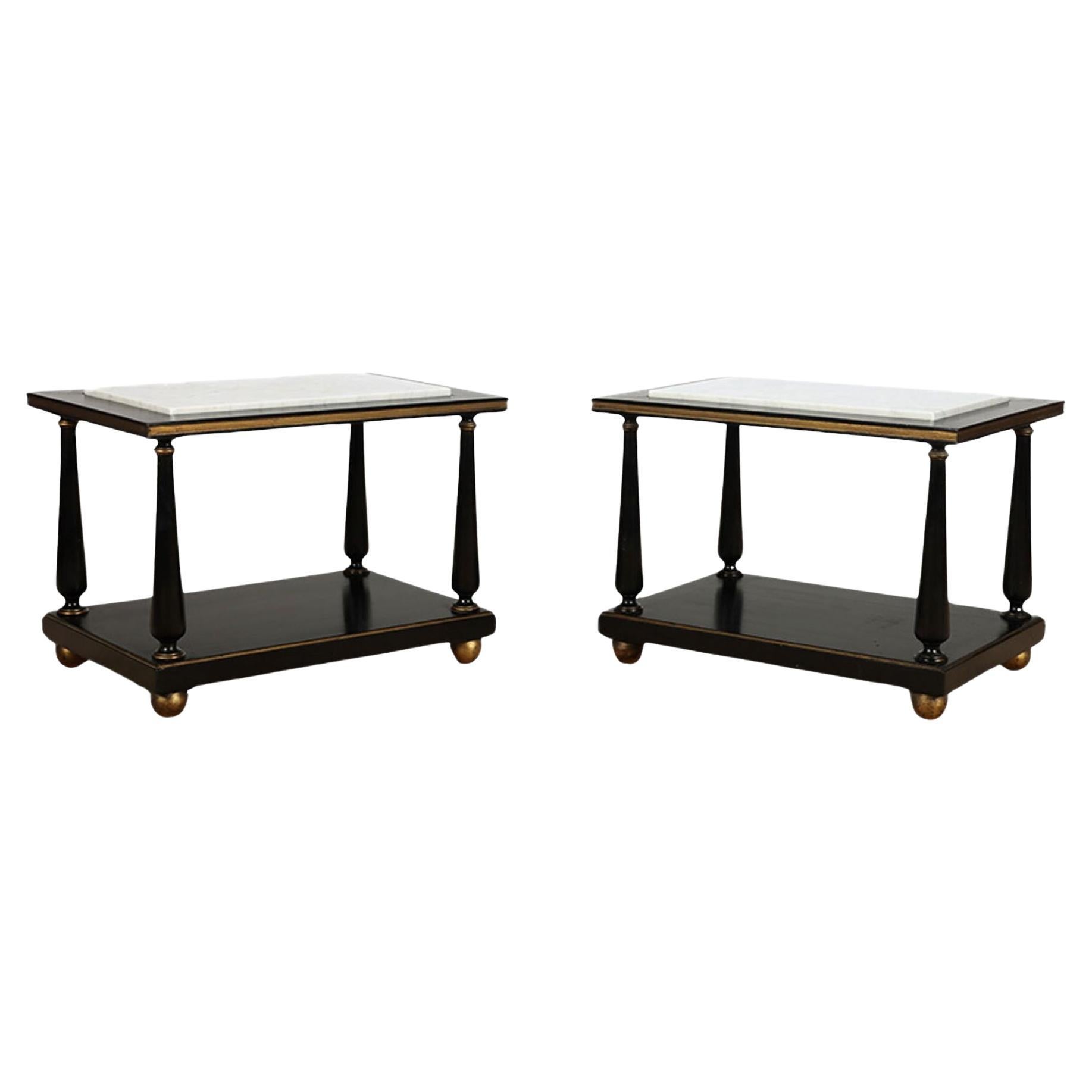 A pair of ebonized and gilt marble top end tables on ball feet circa 1950.