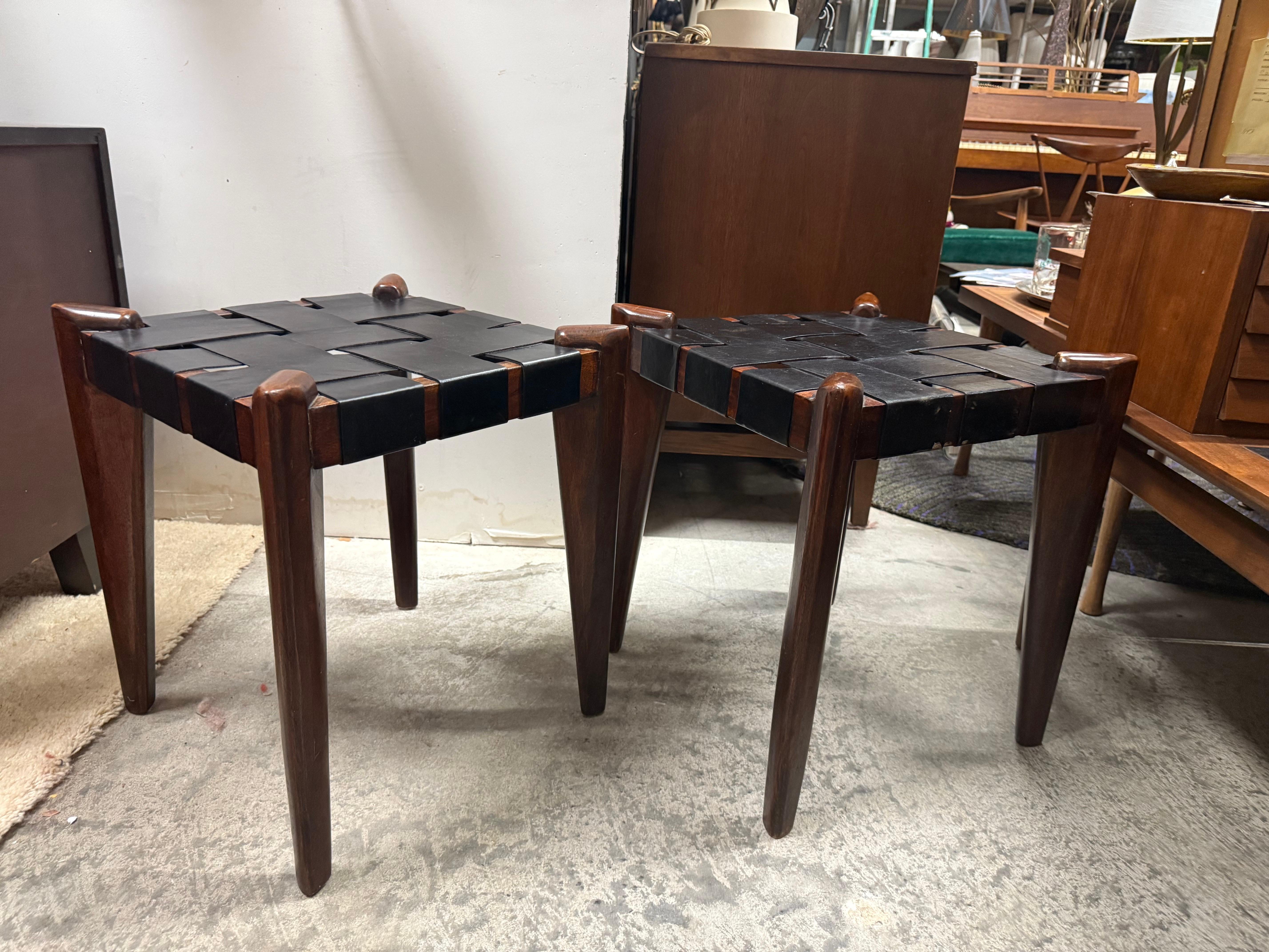 Nous sommes heureux de vous proposer ces tabourets des années 1960 fabriqués par Edmond Spence, avec une structure en teck massif et une assise en cuir tressé. Ces pièces présentent un design sculptural nuancé, où le cuir simple et le bois dur