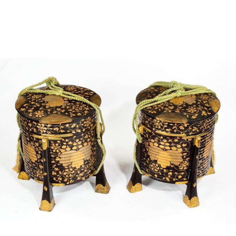 A pair of Edo period black and gold lacquer Samurai helmet boxes (Hakko Bako), each of ribbed cylindrical form with a lid, a black lacquer interior, green tasselled cord and four tapering square-section legs which support the sides of the box, all