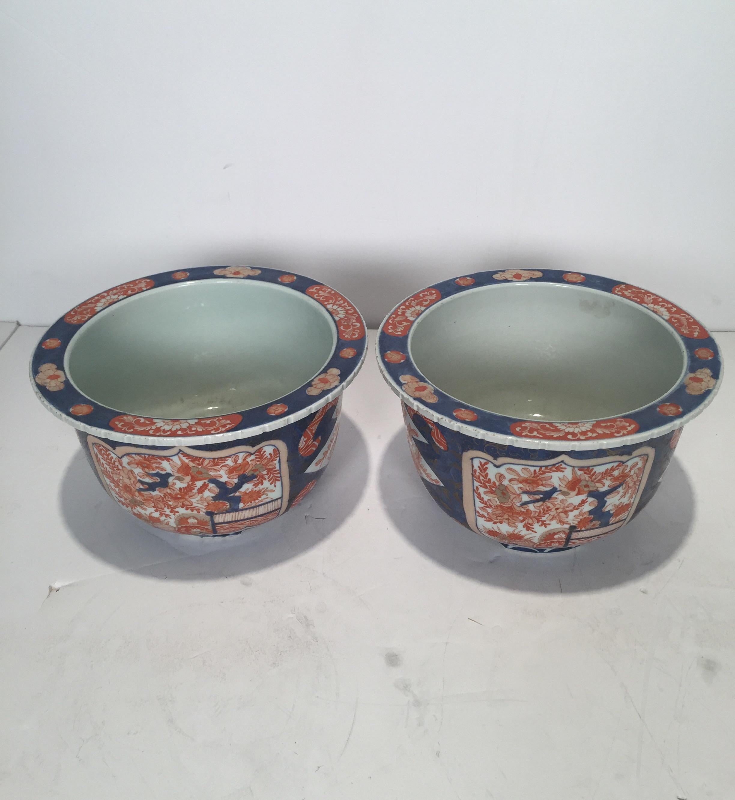 A pair of mid-19th century porcelain Japanese Imari planters, a rare footed pair done in an 18th century design.