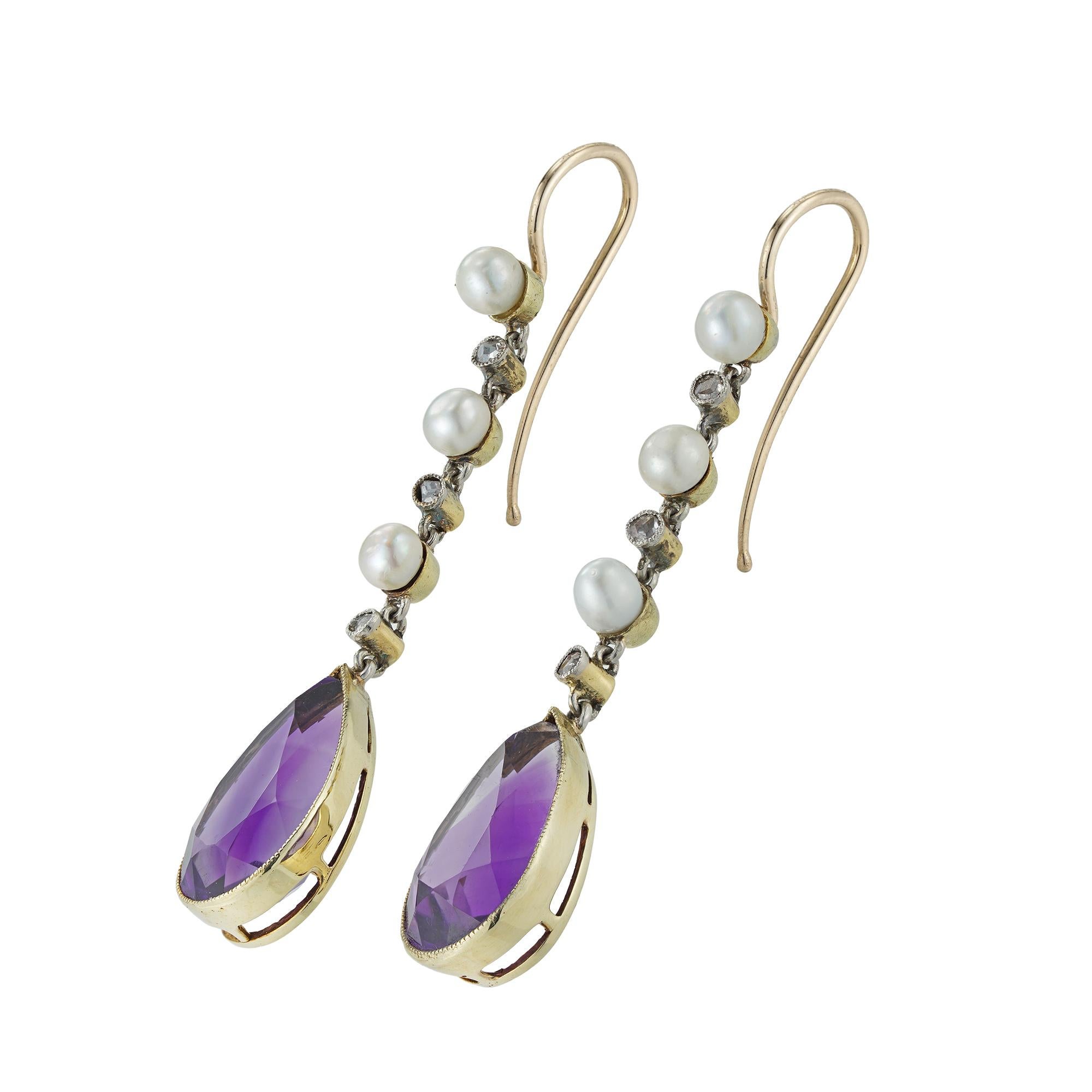 A pair of Edwardian amethyst, pearl and diamond drop earrings, each earring with a pear-shaped amethyst estimated to weigh 8 carats for the pair, suspended by a run set with three small natural pearls alternating with three rose-cut diamonds, all