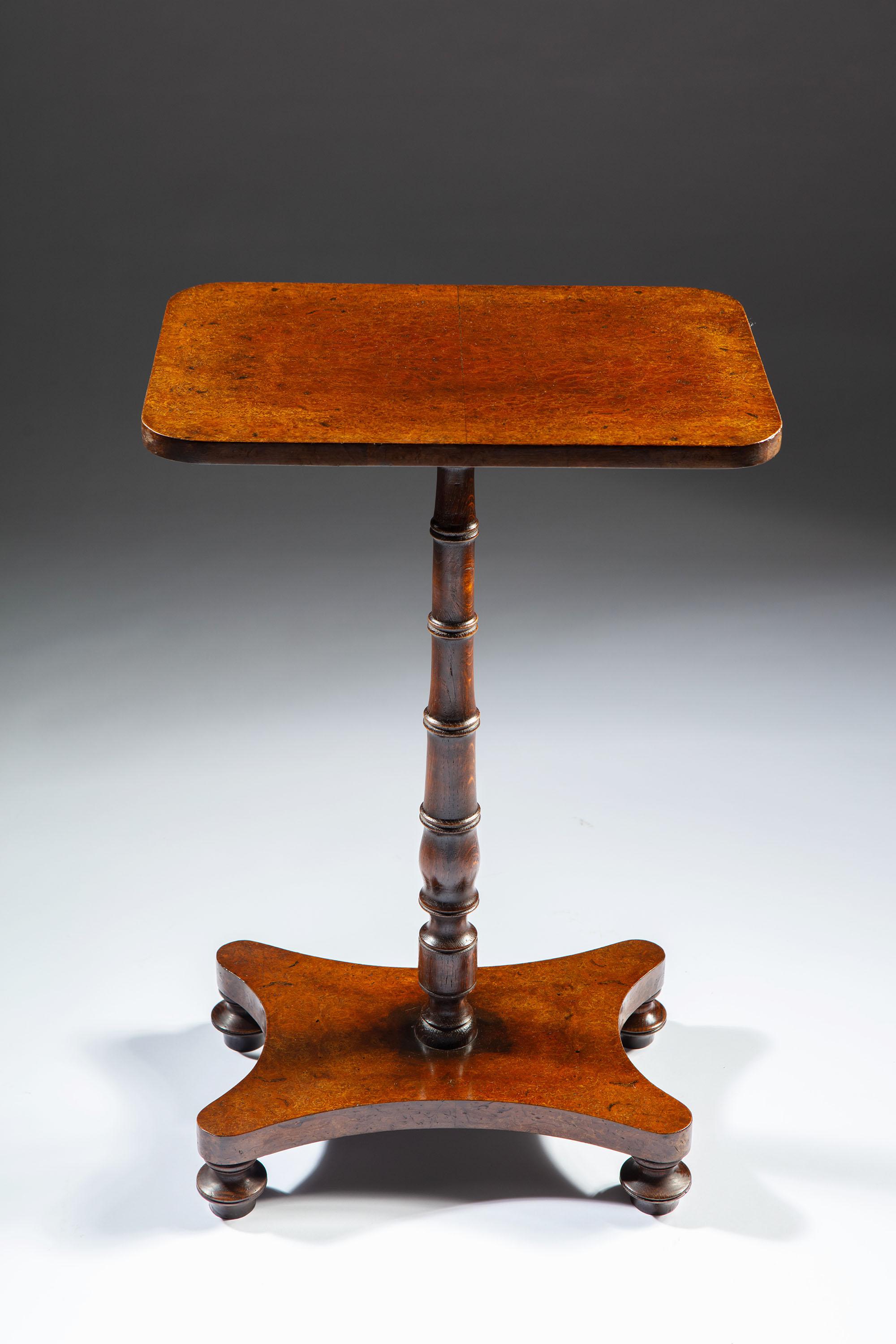 A pair of Edwardian burr oak occasional tables, with rectangular tops and turned stems supported on a quadruped base.