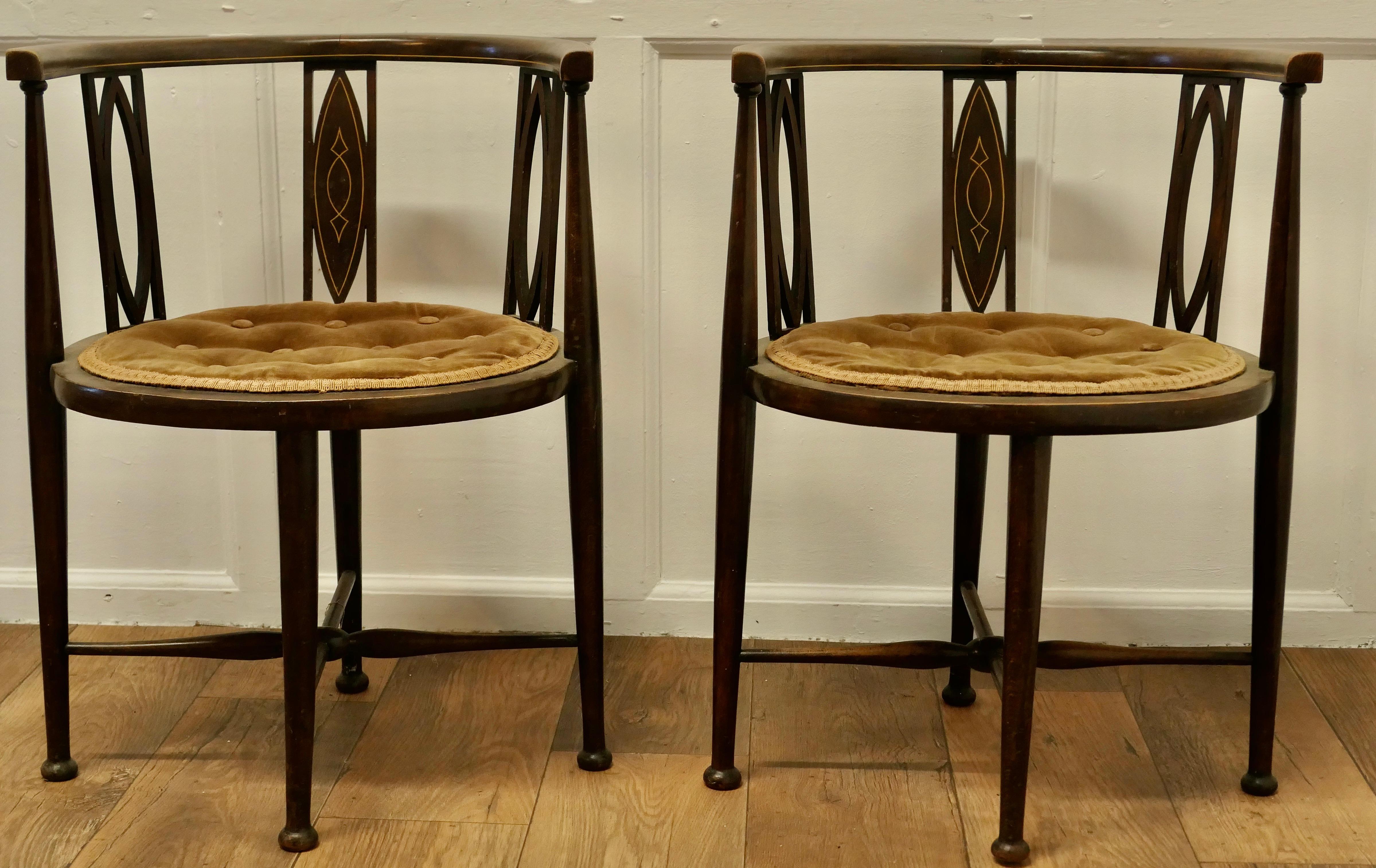 A pair of Edwardian Circular Arm Chairs

A beautiful Pair of occasional chairs and a very unusual shape, the seats are round and the back splats have an oval decoration and shape, the legs are shaped and elegant with x stretchered legs 
The seats