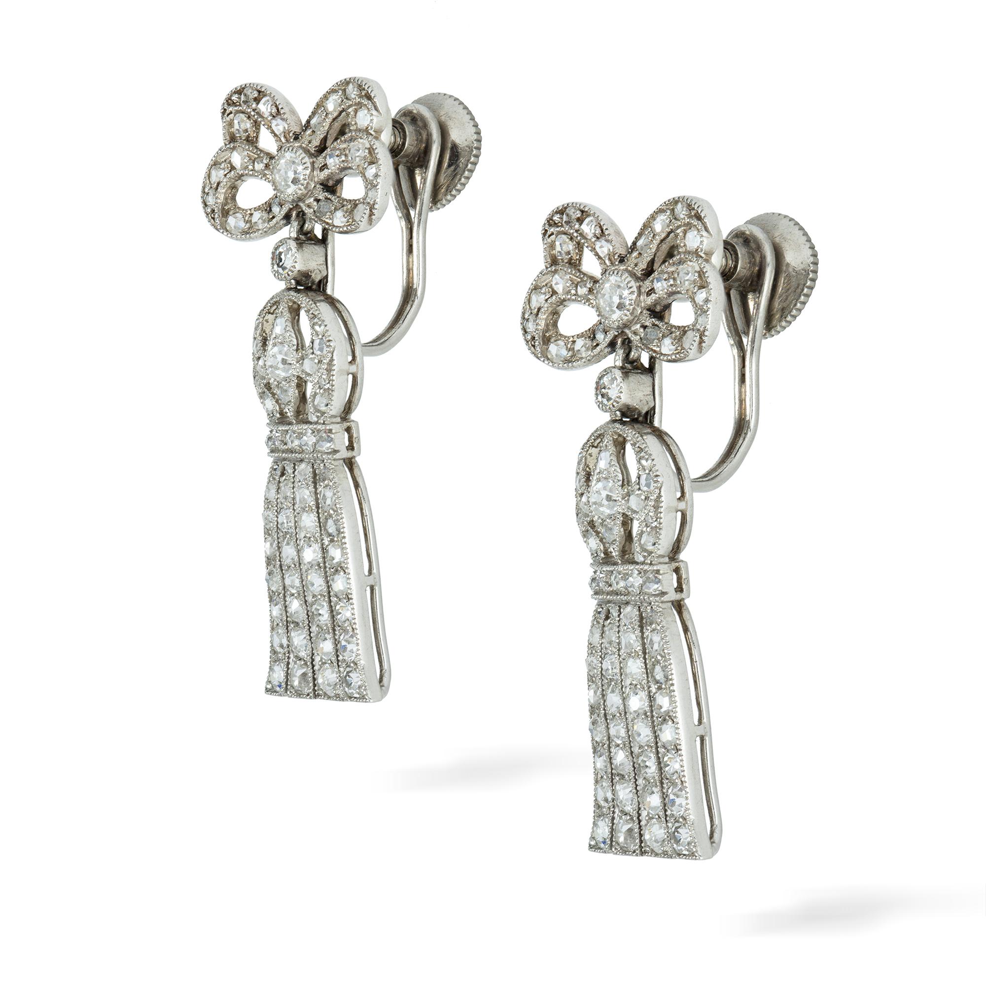 A pair of Edwardian diamond drop earrings, the ribbon bow motif suspending an open work tassel, set throughout with old- and rose-cut diamonds, all in a platinum millegrain setting, circa 1910, measuring approximately 3x1.1cm, gross weight 6.5