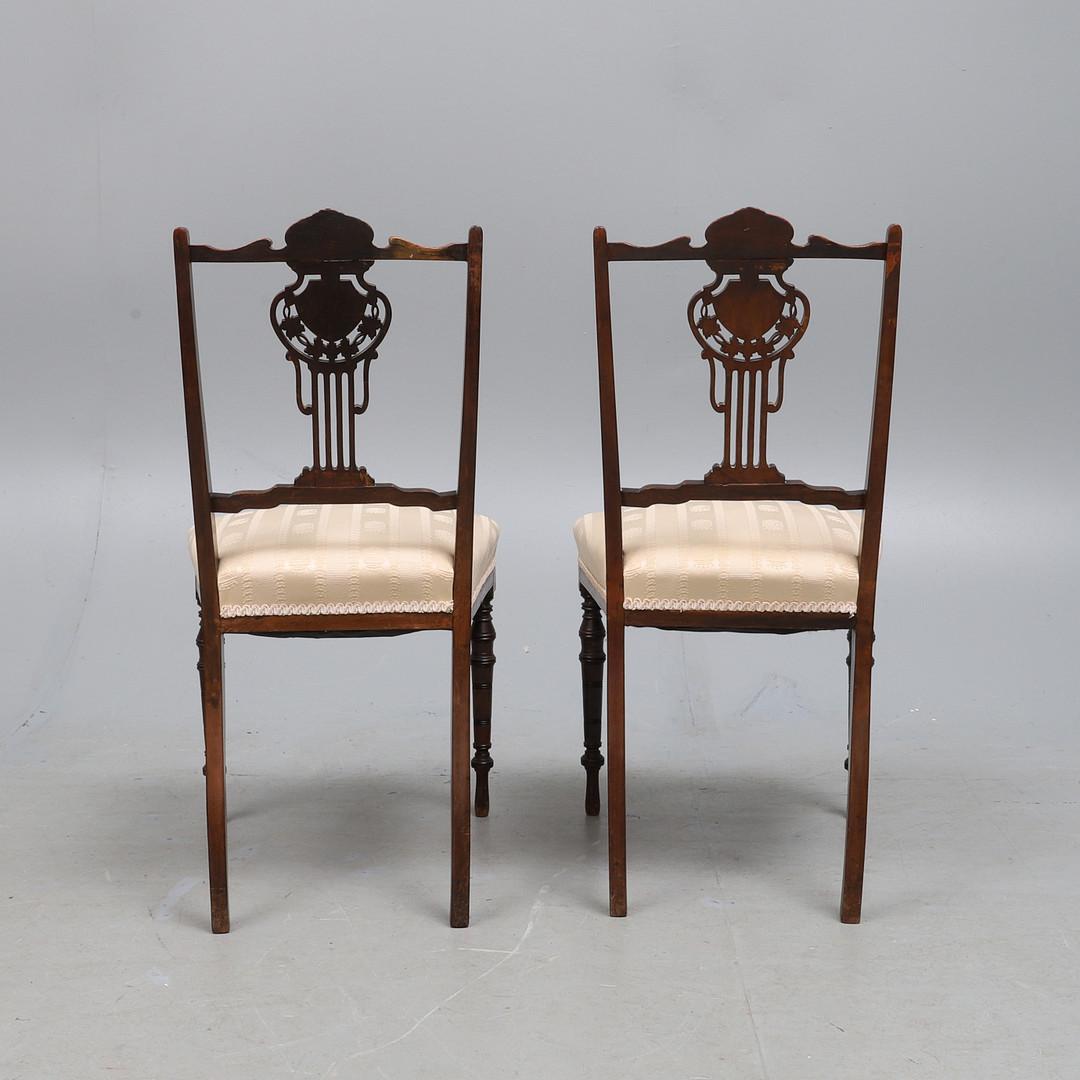 Magnificently created a set of decorative antique Edwardian English seats. The shaped top rail is inlaid with leafy scrollwork above a pierced splat, the stuff-over seat upholstered in a shield and crown motif striped fabric on turned cylindrical,