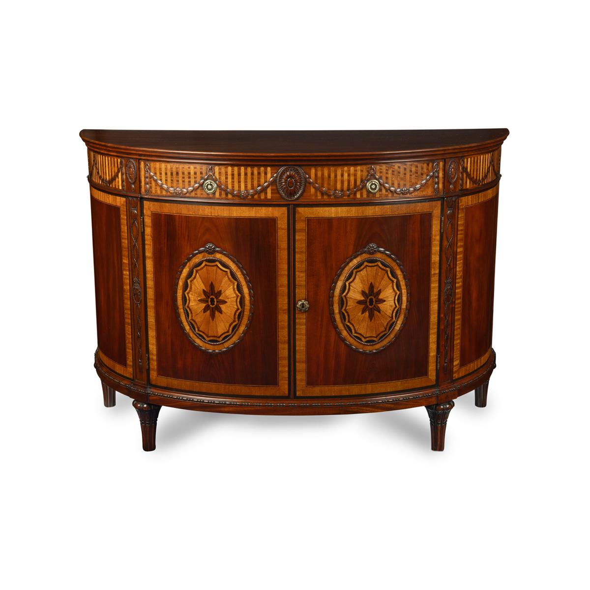 A pair of Edwardian mahogany commodes, each of semi-circular form with a single oak-lined frieze drawer above a pair of doors which open to reveal three sliding shelves, decorated with satinwood blind fluting and marquetry around the frieze, the