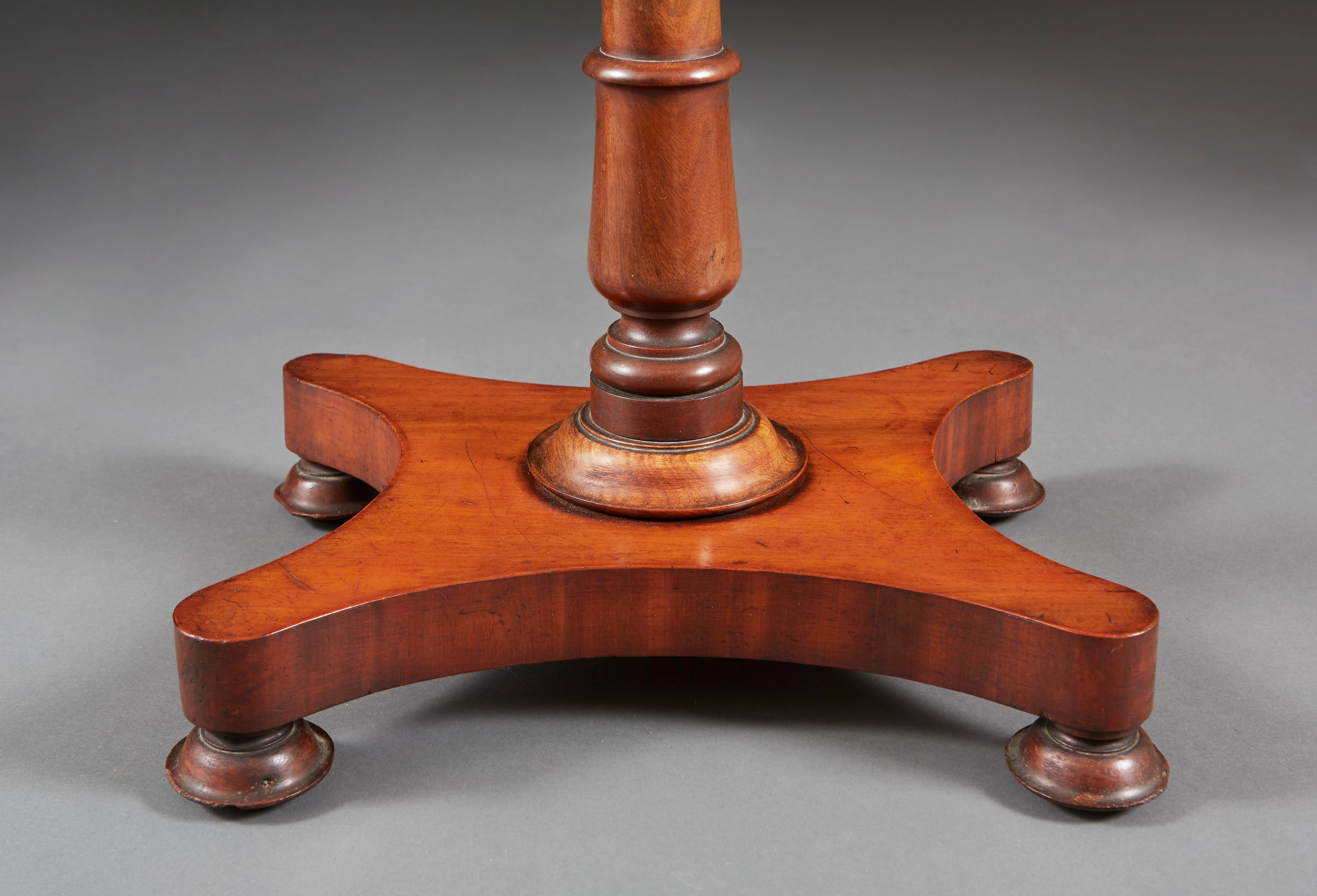 A pair of Edwardian mahogany occasional tables with rectangular tops and turned stem, all supported on concave platform bases.
