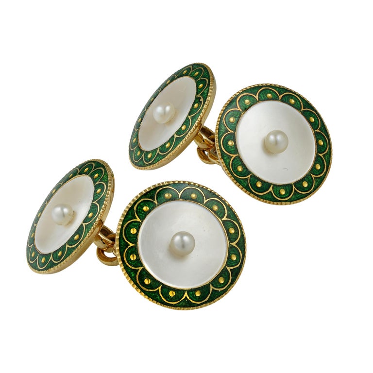 A pair of Edwardian mother of pearl and enamel cufflinks, each cufflink with two circular plaques, each centrally set with a pearl on a concave mother-of-pearl background, with a fine green champleve enamel border, mounted in yellow gold with gold